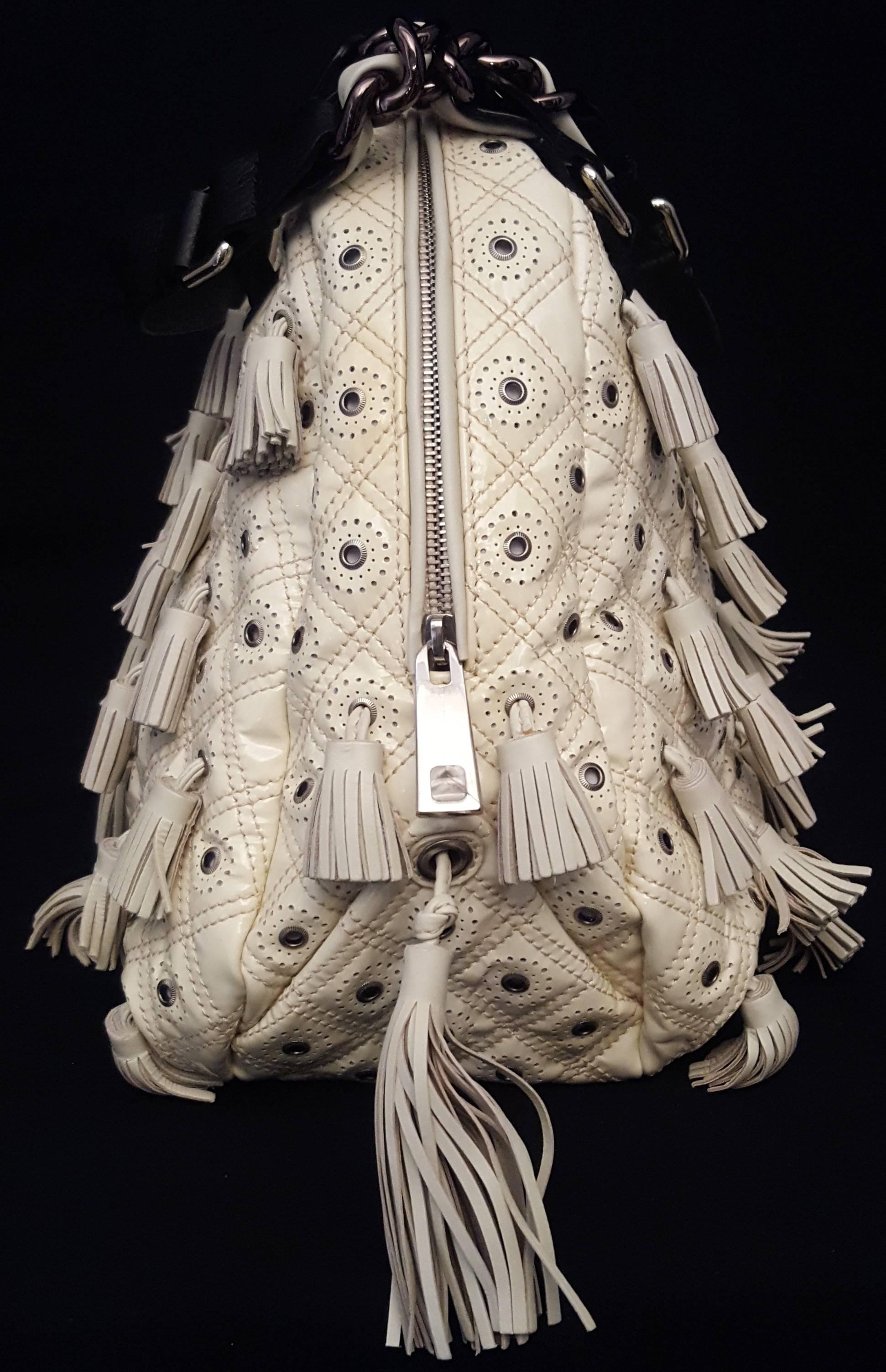 Marc Jacobs ivory patent leather Dancer bag is from the spring/summer 2010 collection featuring perforated leather with grommets and tassels details all over this outstanding bag with 2 larger tassels at each side.  This bag is lined in gold tone