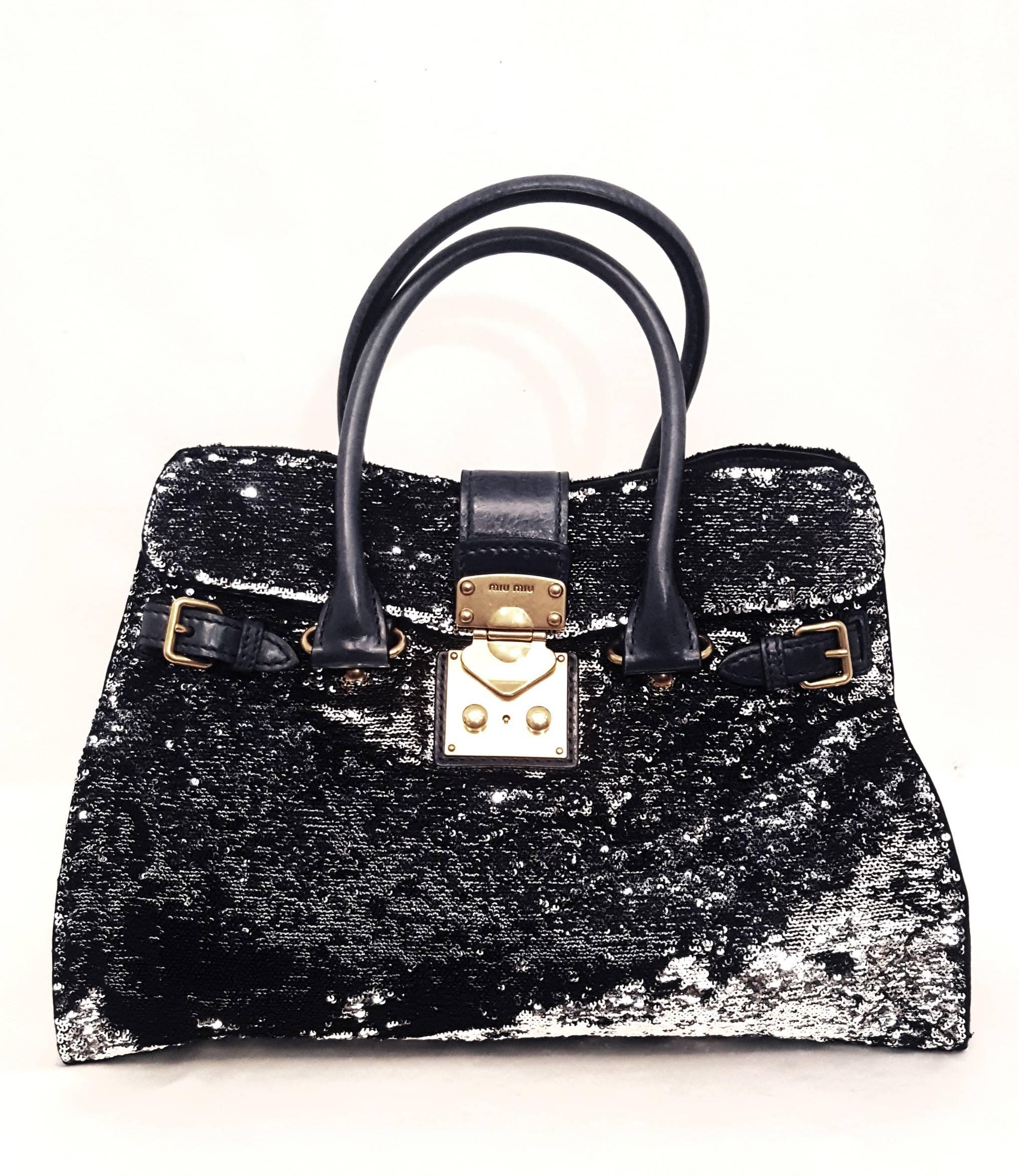 Miu Miu Paillettes black/silver tone double sided sequin argento shopping tote that features two tall rolled  leather top handles with polished gold hardware. This chic tote is finely crafted of black & silver tone double sided sequins that change
