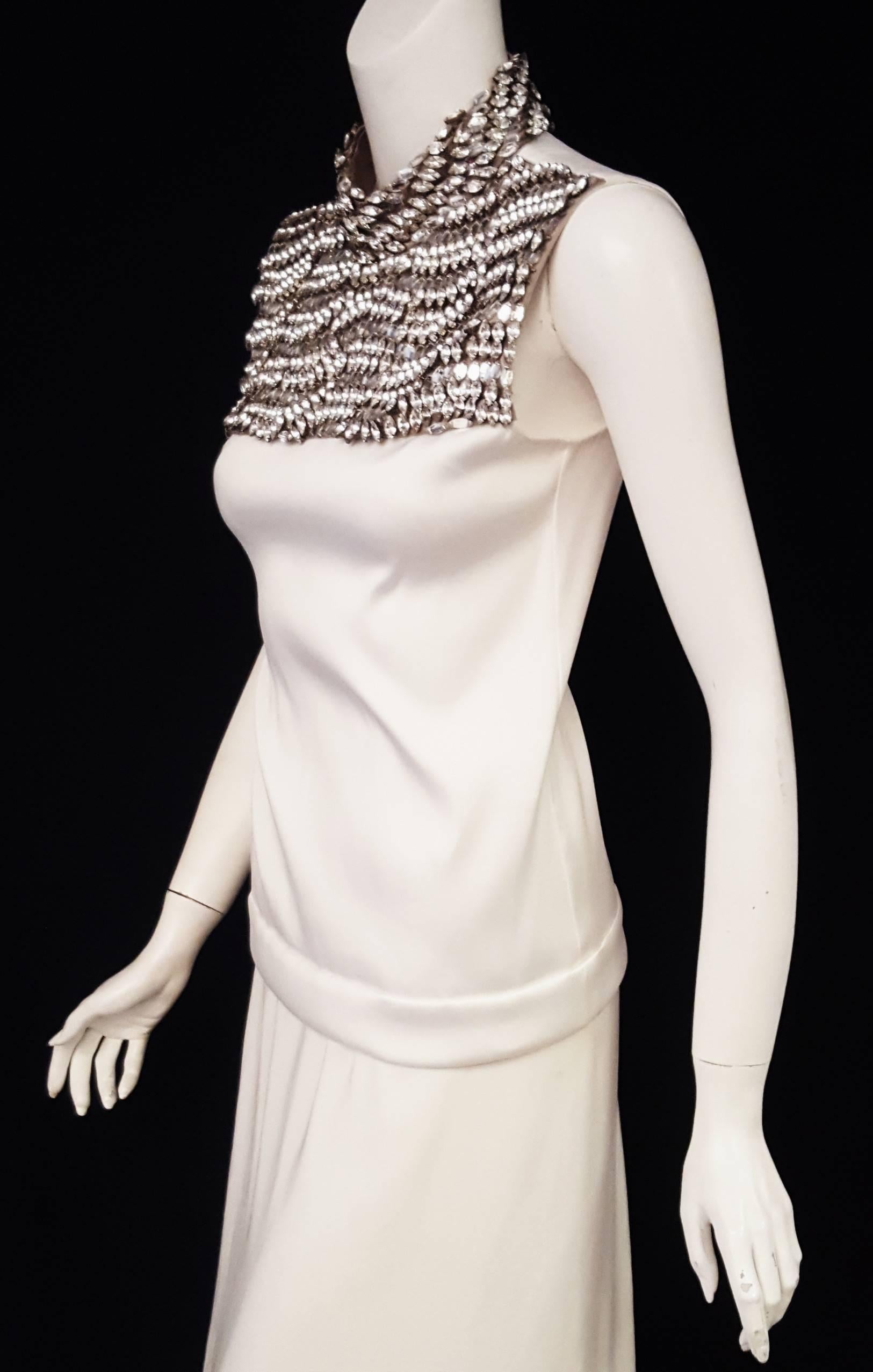 Make an unforgettable entrance with this Prada white sleeveless blouse features taupe stand-up collar and bib encrusted with large Marquis cut crystals!   The crystals  are set in flat rows on fabric with alternating rows raised with gold tone bugle