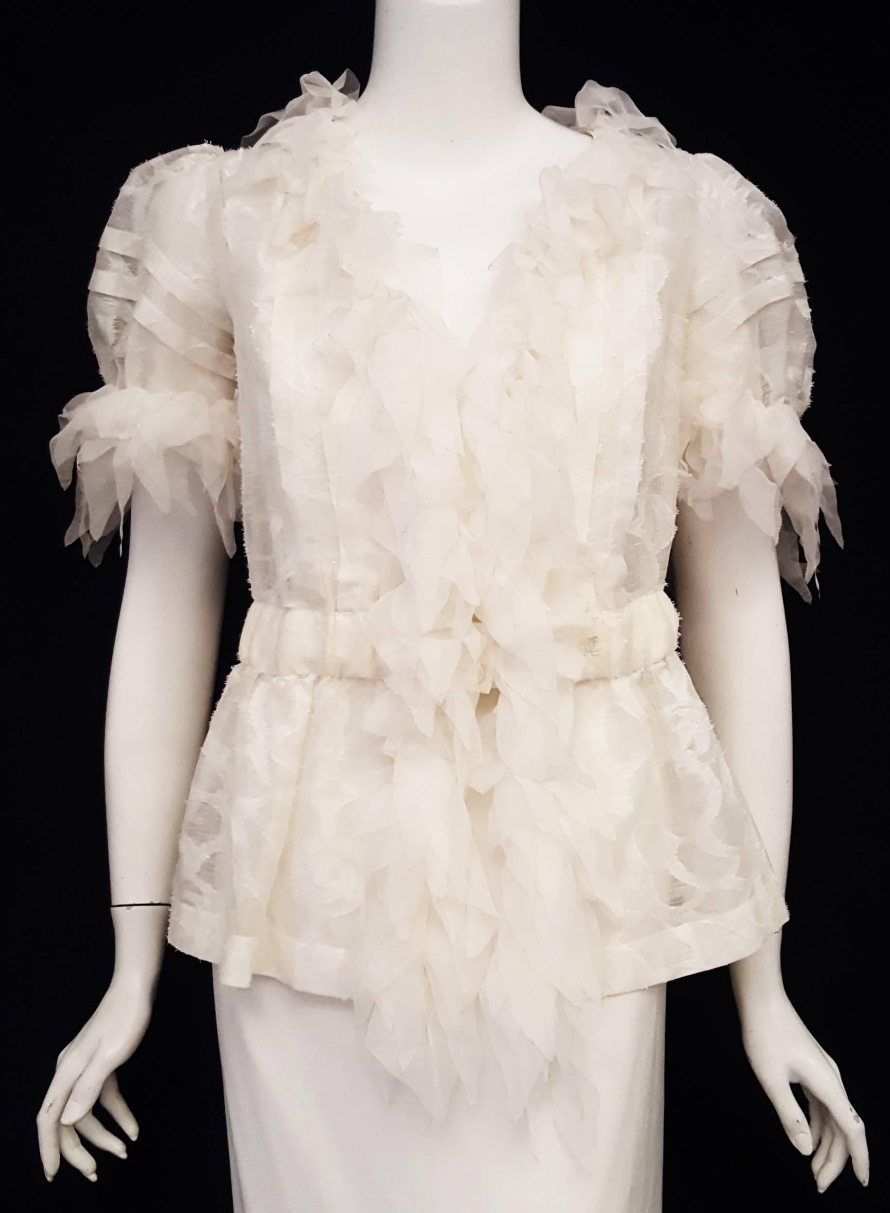 Chanel features white on white on this sheer frayed silk short sleeve blouse with petals /leaves on the collar and at front opening for a sensual cascade from neck to hem.  The short sleeves are also decorated with the unique petal ruffles.  On this