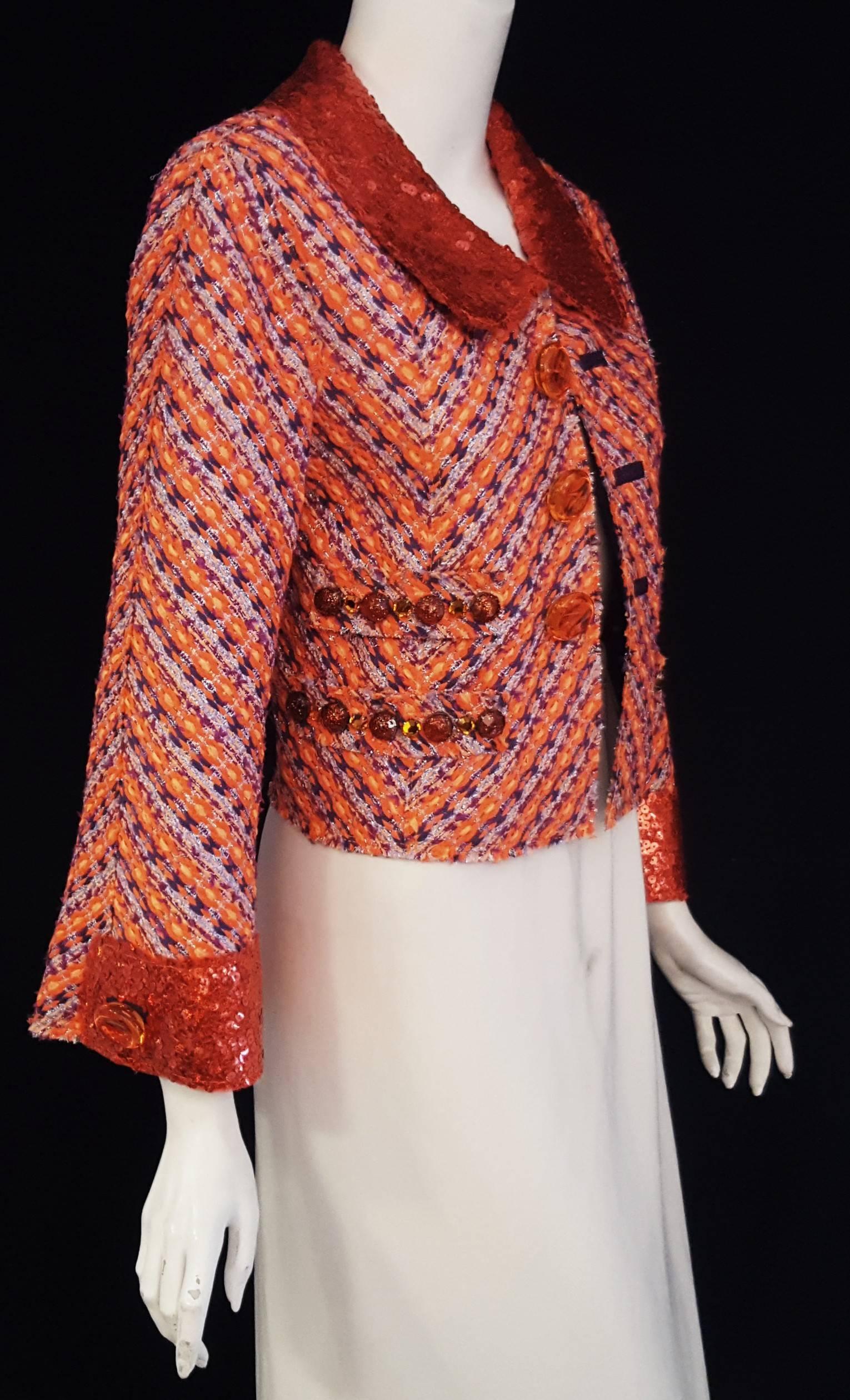 Marc Jacobs three dimensional stripe orange tweed jacket features an orange sequined collar and cuffs at full length sleeves with single plastic button.  Two faux pockets on each side of jacket with 4 buttons and 4 crystals on each faux flap of the