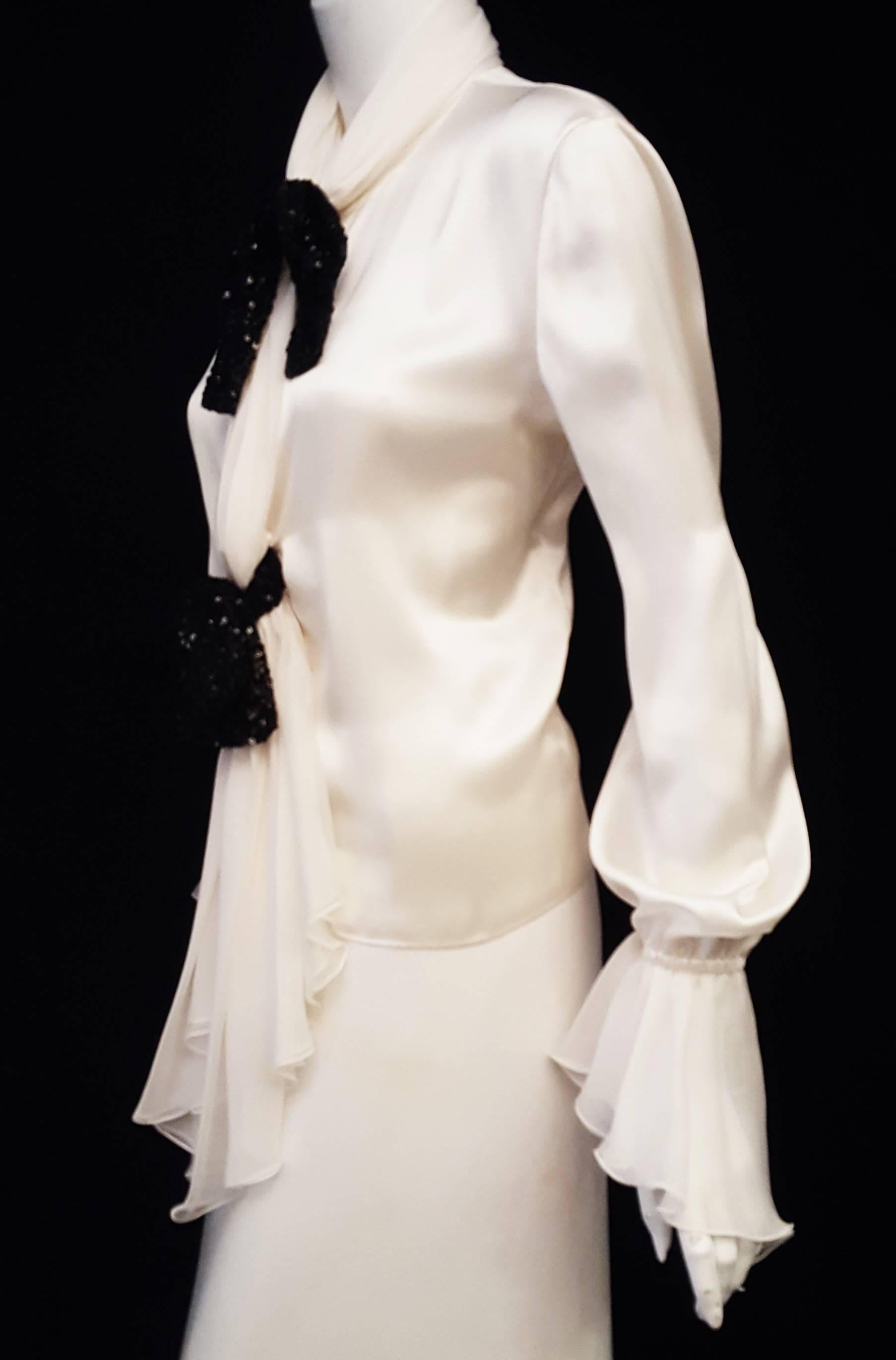 Valentino ivory silk long sleeve blouse with gathered bell cuffs in silk chiffon delivers a soft, sophisticated and feminine look.  The collar is like a draped silk chiffon oblong scarf that cascades down the front and has 4 buttons.  At the
