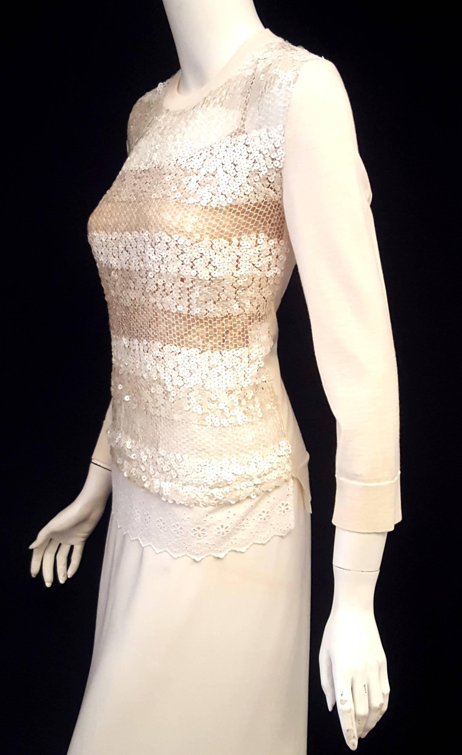 Louis Vuitton ivory sequined wool & silk top features a crew neck ribbed collar and  cuffs with back hem fashioned from the same wool and silk fabric as the back panel of this sweater.  The front is covered in 3 different shades of sequins in white,