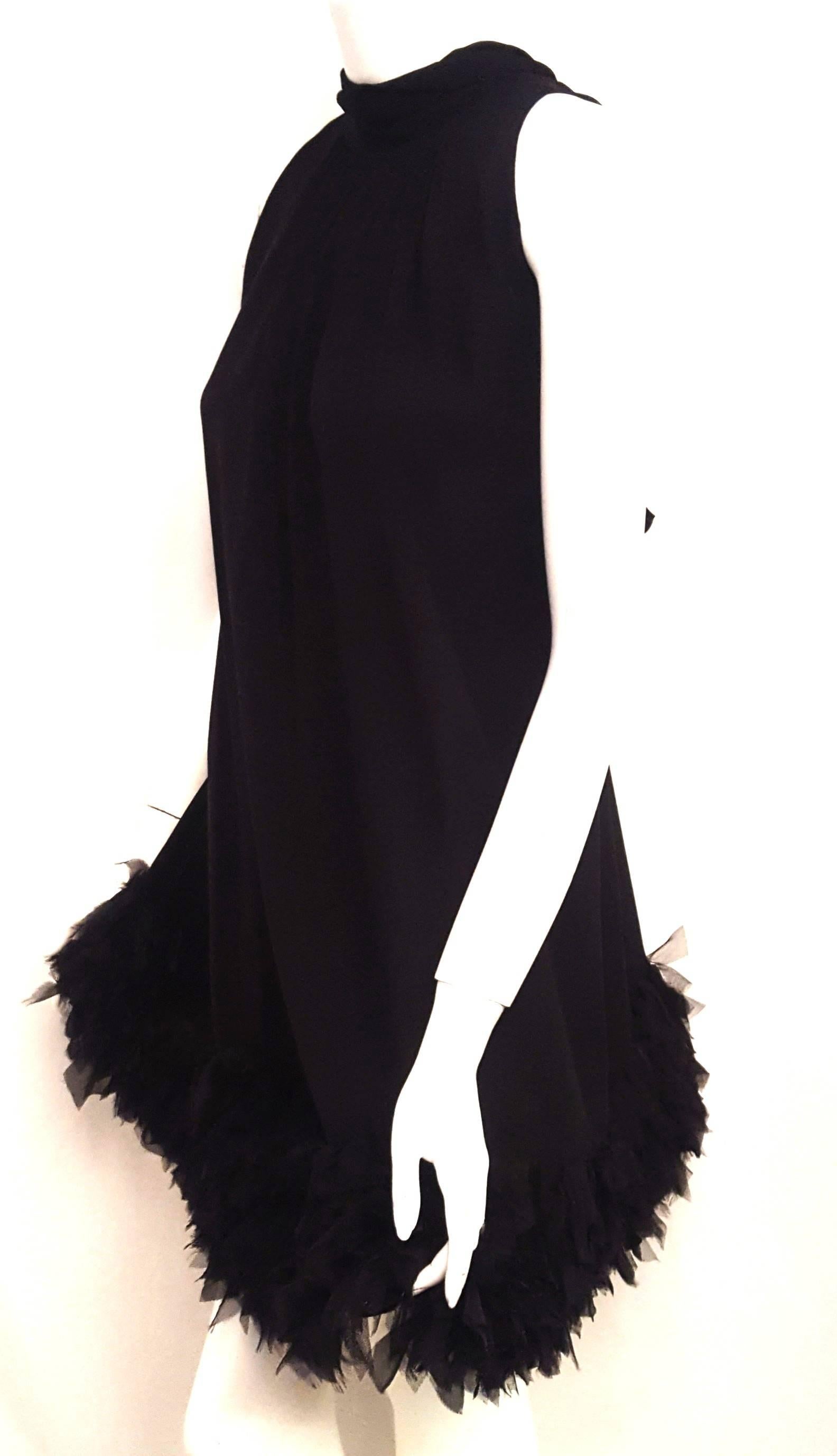 D & G black silk chiffon sleeveless dress with turtleneck style collar with long sashes that tie at back in a bow or can, also, be tied at front to accentuate the feminine look.   This loose fitting flirty dress falls to just below the knee.  The