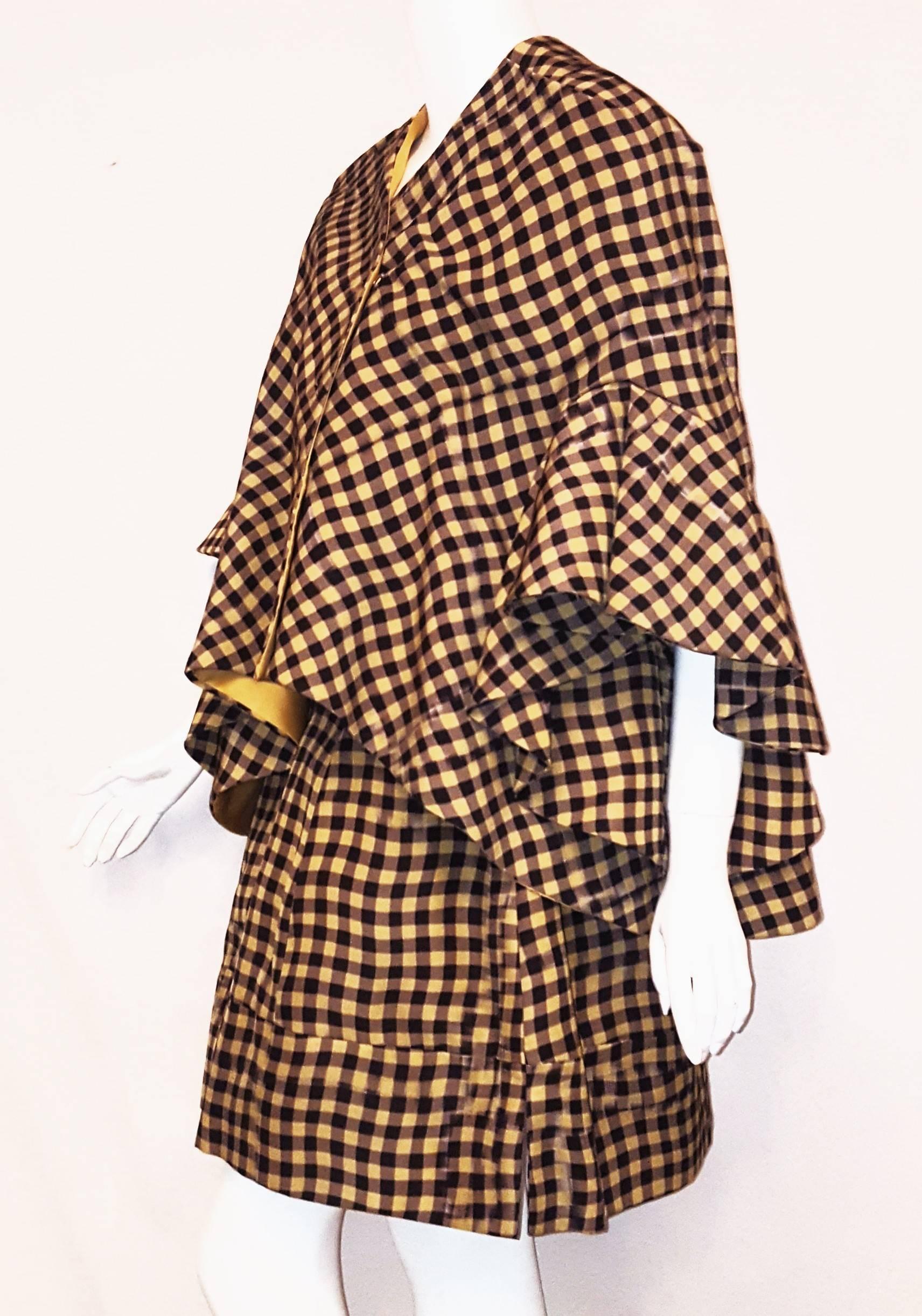 Delpozo brown and yellow check print jacket has exaggerated bell sleeves that are the focus of this ensemble.  This V neck double breasted jacket has 4 hidden snaps for closure.  The front of the jacket is 6 inches shorter than the rounded back. 