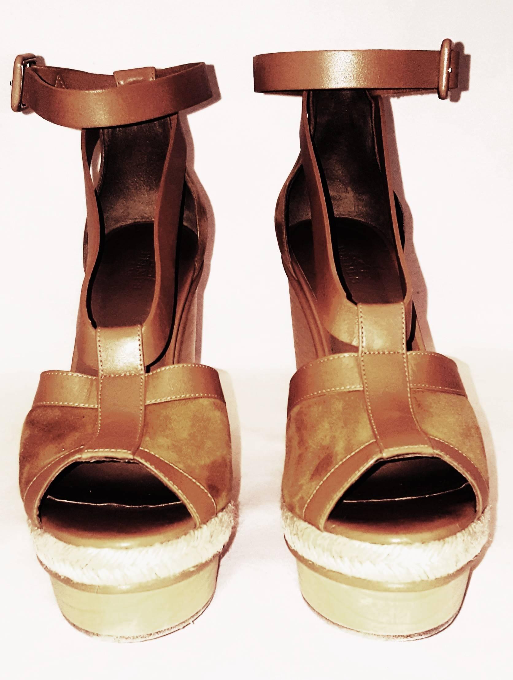 Hermes tan suede and leather with wooden platform wedge Ibiza sandals have peep toe opening at front and leather and suede strap uppers.  For added comfort and stability, there is an ankle strap in tan leather.  These sandals are lined in leather