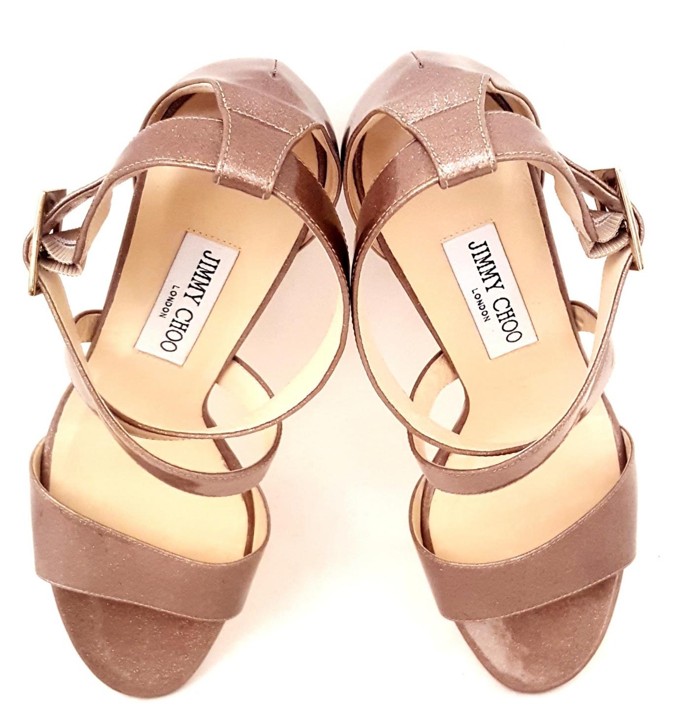 Jimmy Choo Fearne taupe patent leather with encrusted glitter wedges contain criss cross straps across the upper that are buckled at the ankle with two straps and gold tone buckles.  The beige leather insole and leather sole  are in excellent