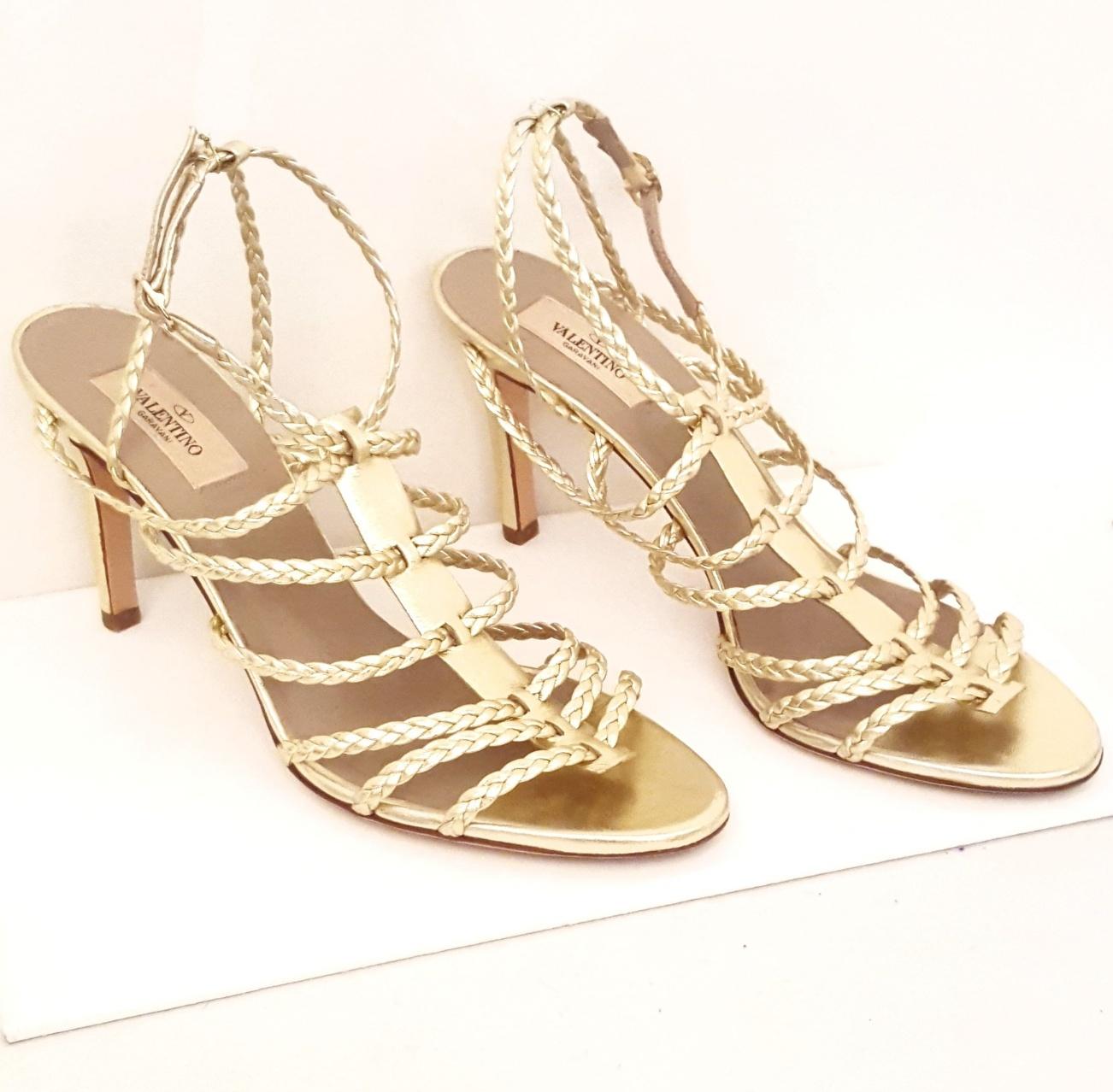 Valentino gold tone braided straps are interlocked and attached with a leather gold tone strip at center.   With a back strap and an ankle strap for support, these woven evening sandals give any little black dress the glamour and style desired. 