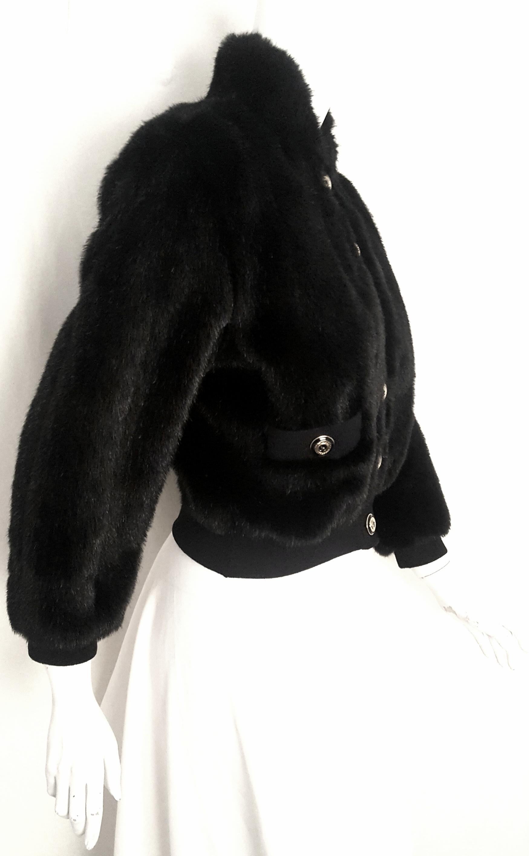 St. John black faux fur bomber style jacket is very versatile as it can be converted to from jacket to vest by removing the sleeves that are attached by a zipper at each side.  It is an outstanding Marie Gray design cropped jacket with up collar and