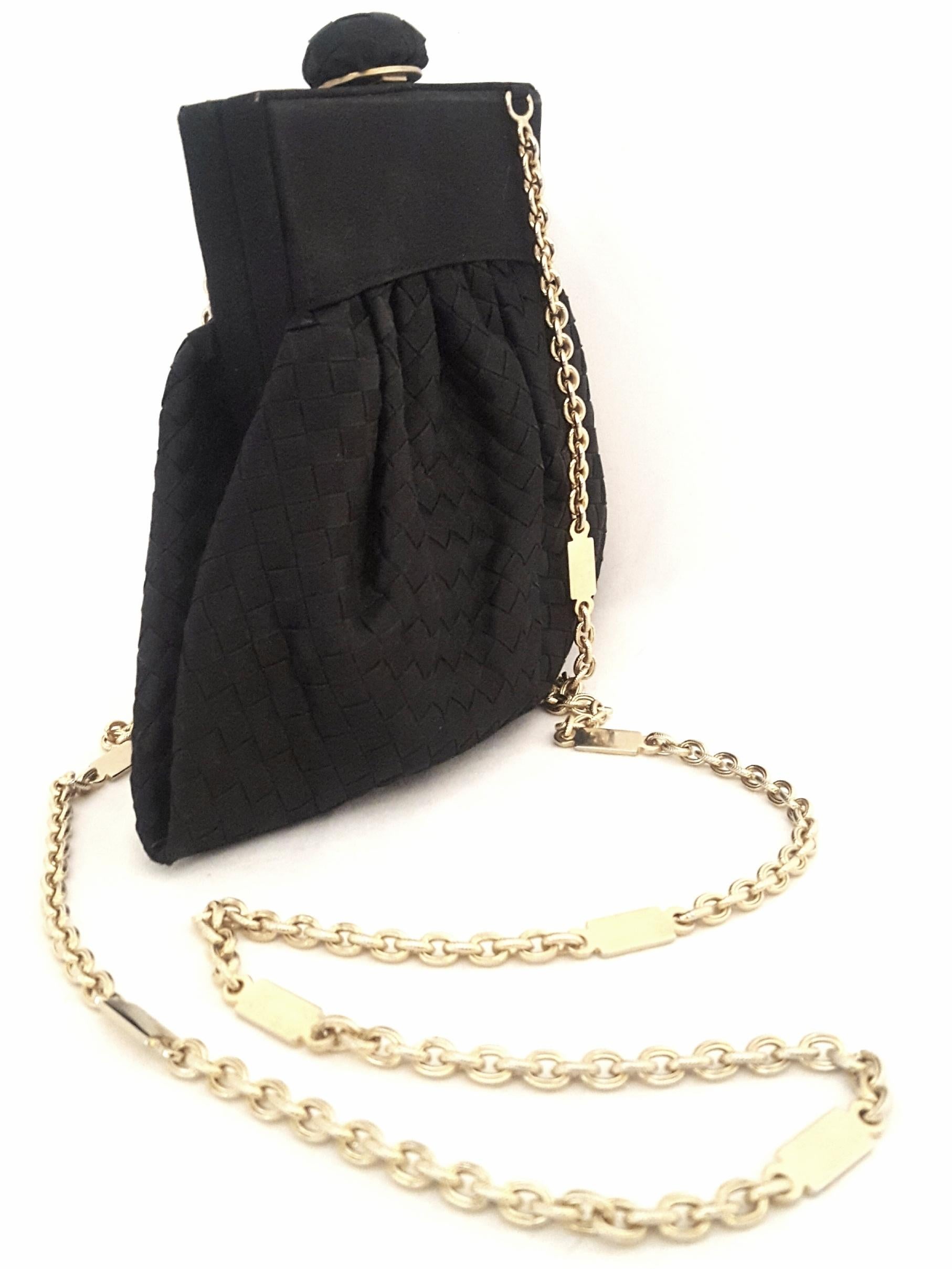 Bottega Veneta vintage black satin intrecciato (woven) mini bag contains an elaborate gold tone shoulder strap. 
With the signature intrecciato woven pattern adorning the distinct shape of this small structured bag it features a satin and gold tone