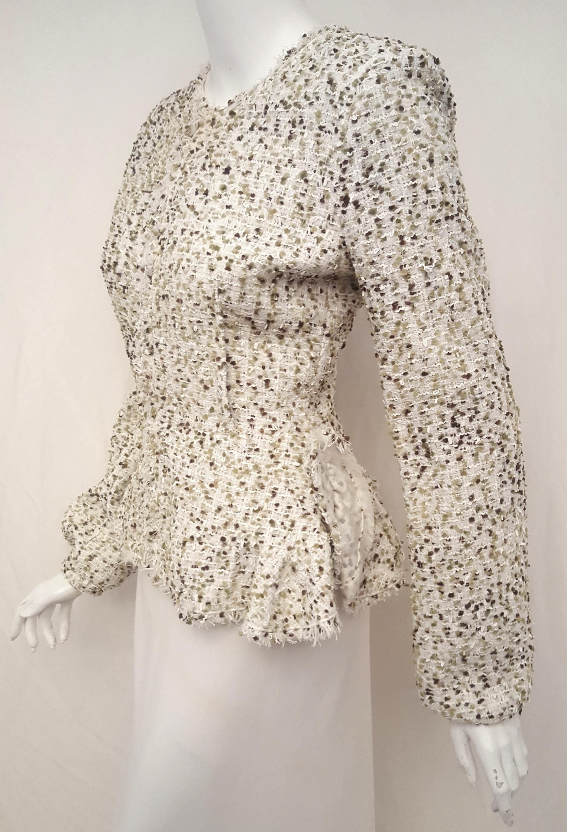 Giambattista Valli's bouclé jacket is the picture of ladylike elegance with a soft silhouette. The textured fabric features green, brown and white yarn intertwined with gold tone threads throughout for a playful and glimmer element. This no collar
