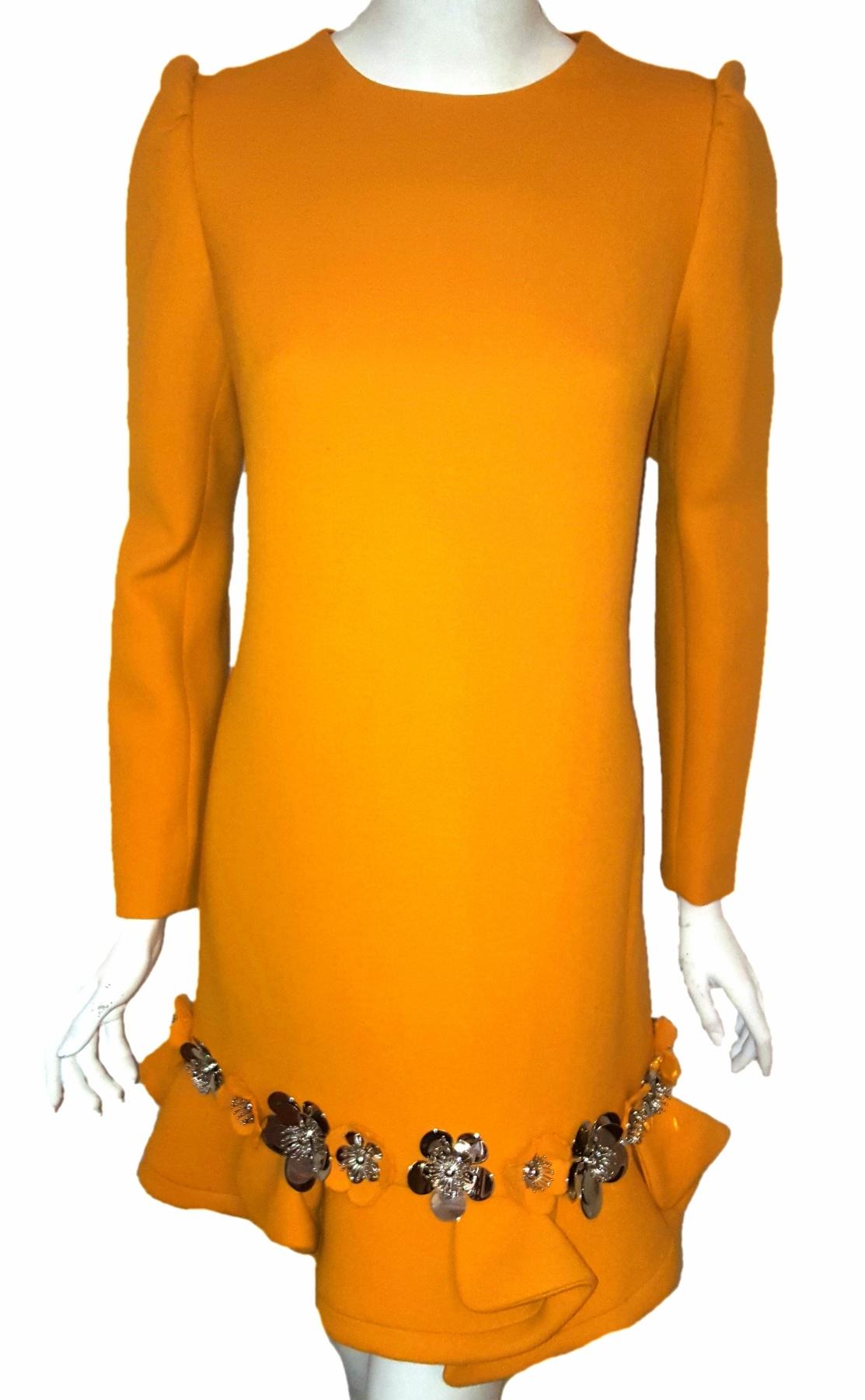 Miu Miu butternut squash long sleeve dress with floral decorations adorning the hemline of this dress continues the sweet fragrance trend of flower petals subtly suggested by scalloped edges.  A full row of silver tone metal flowers that appear