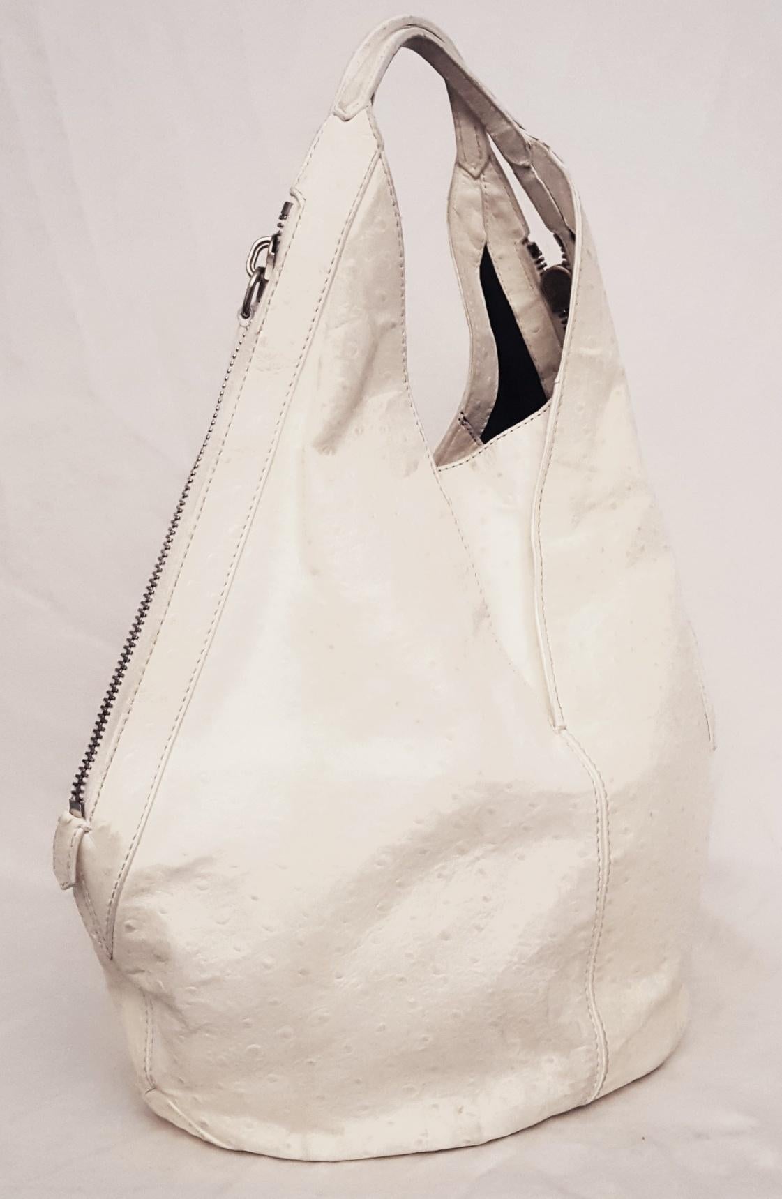 Givenchy ivory Tinhan ostrich leather Hobo bag by Riccardo Tisci  features 2 side zippers for closure.   This bag is lined in black canvas.  The interior pocket contains one zipper pocket and one slit pocket.  Made in Hungary.  Fits all of your