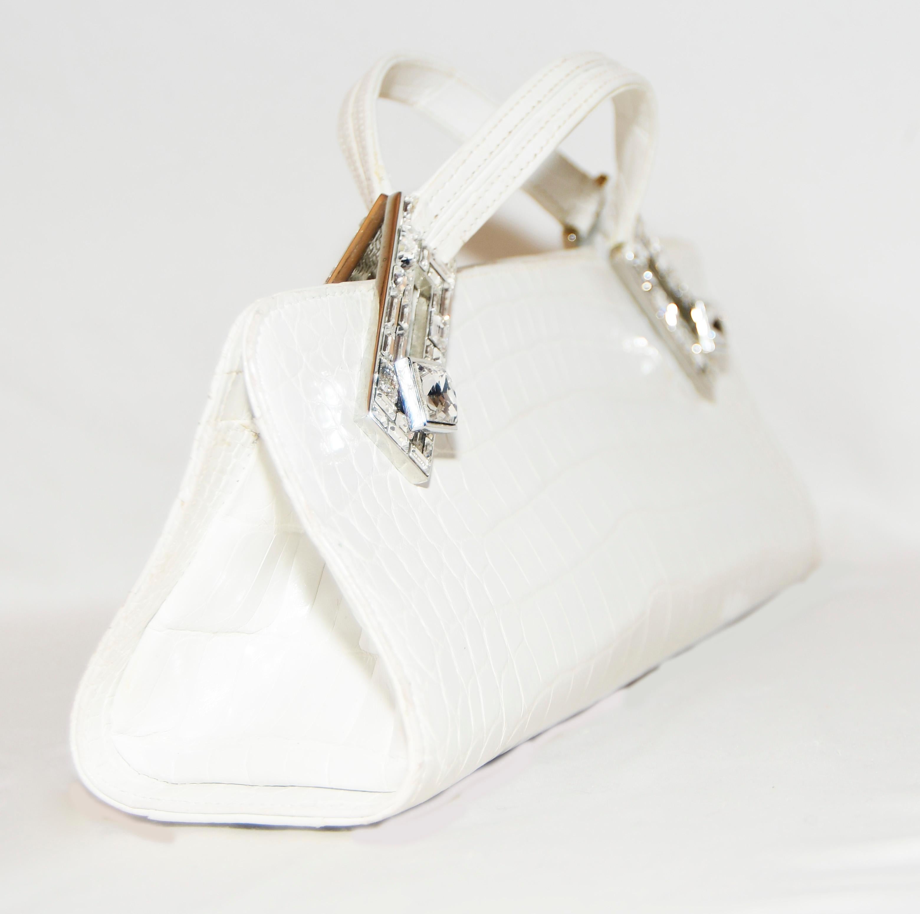 Judith Leiber  Art Deco white Croc clutch bag  with straight simple lines includes a handle at each side that has crystal inlaid hardware that swivels to create the handles.  The interior is lined in copper tone metallic satin with one zippered
