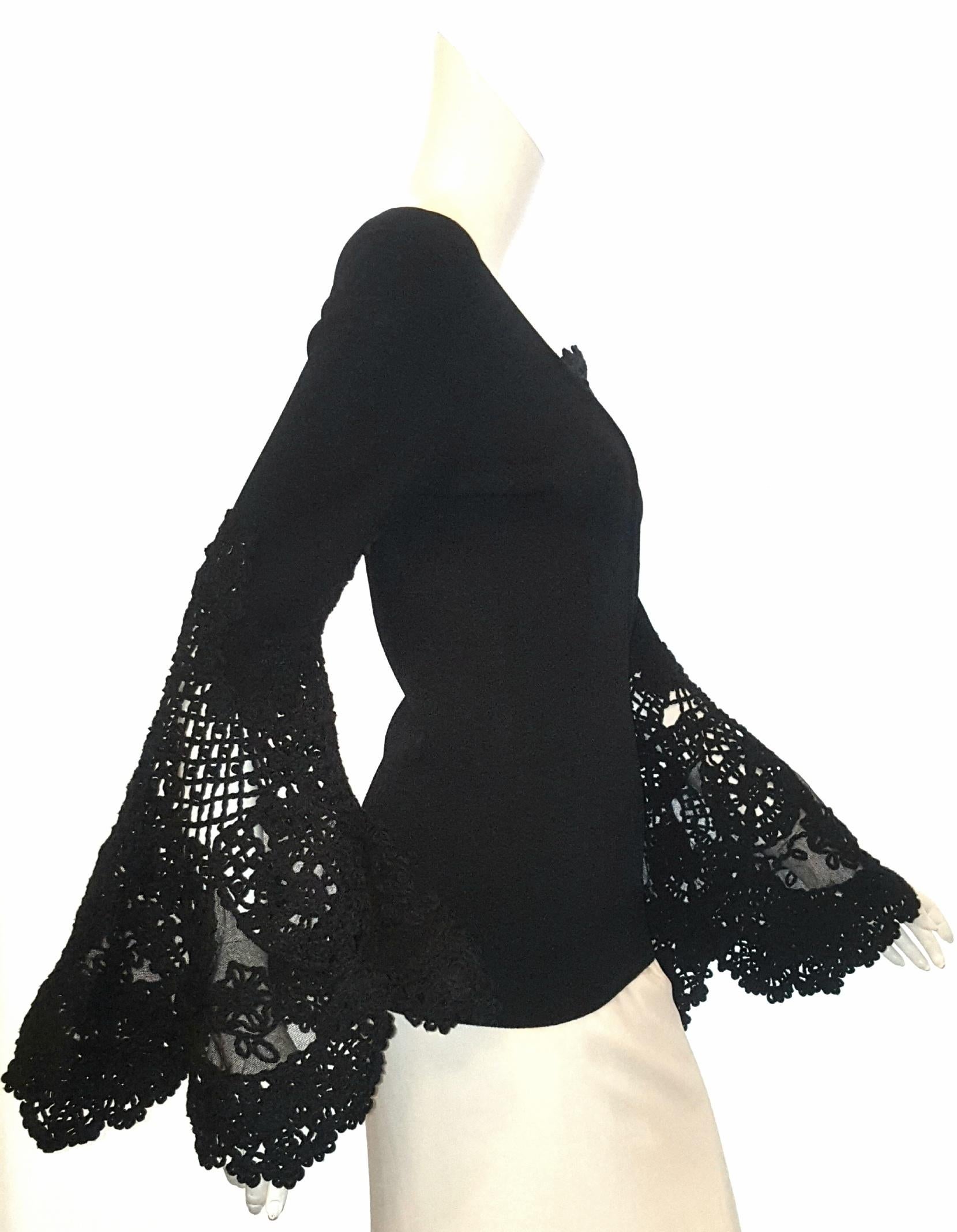 Chanel black crocheted  and embroidered flared sleeve top is a staple piece and features a V neck with crochet insert, at the neckline. The long sleeves flared out to an extreme bell cuff crocheted in a lace  motif.    With a fitted waist and close
