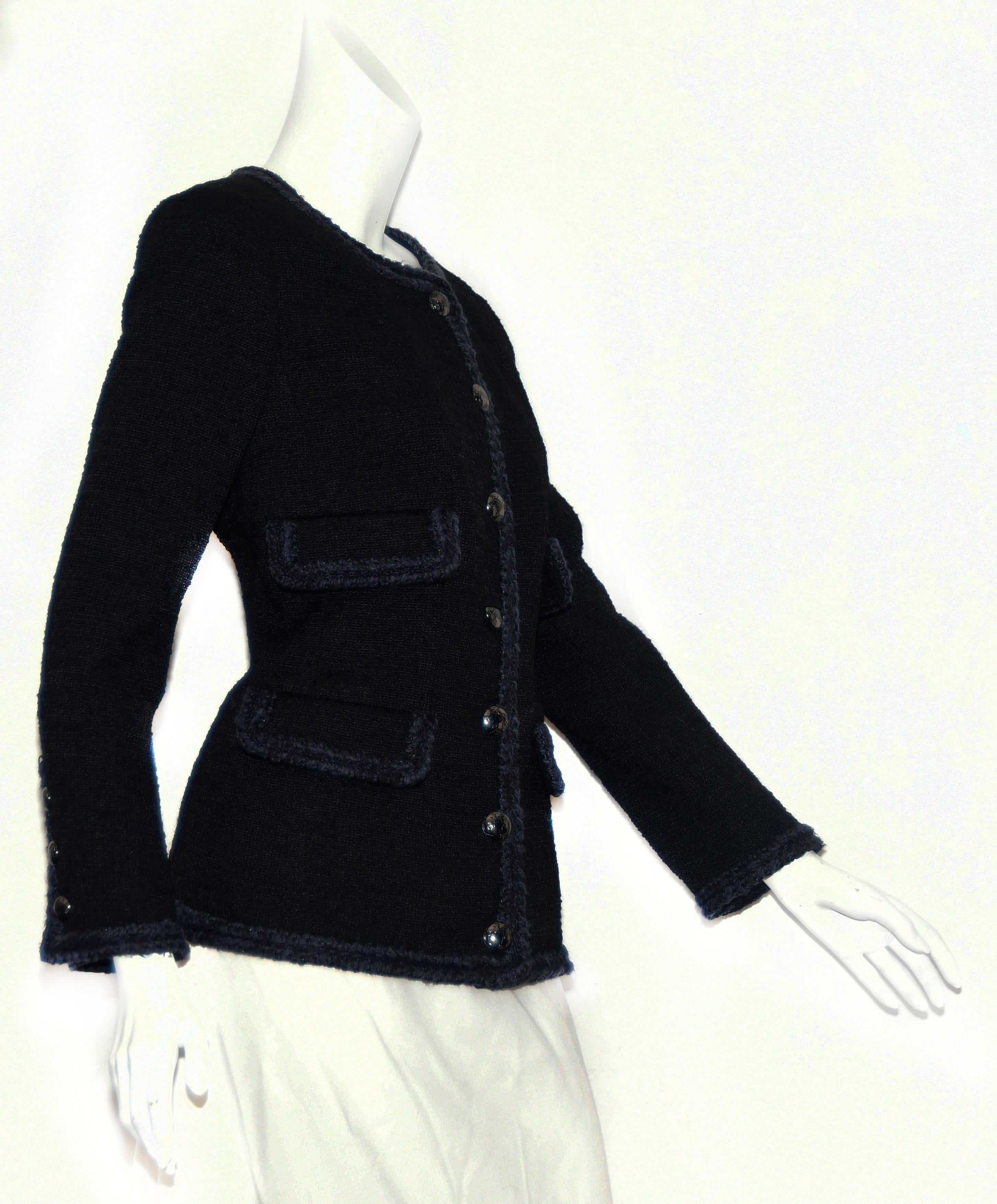 Chanel black 2013 fall collection jacket that incorporates four flap pockets with braided trim.  The essence of the 2013 Chanel collection came from Scotland and the time that Coco spent there.  The venue was Linlithgow Palace, where Mary, Queen of