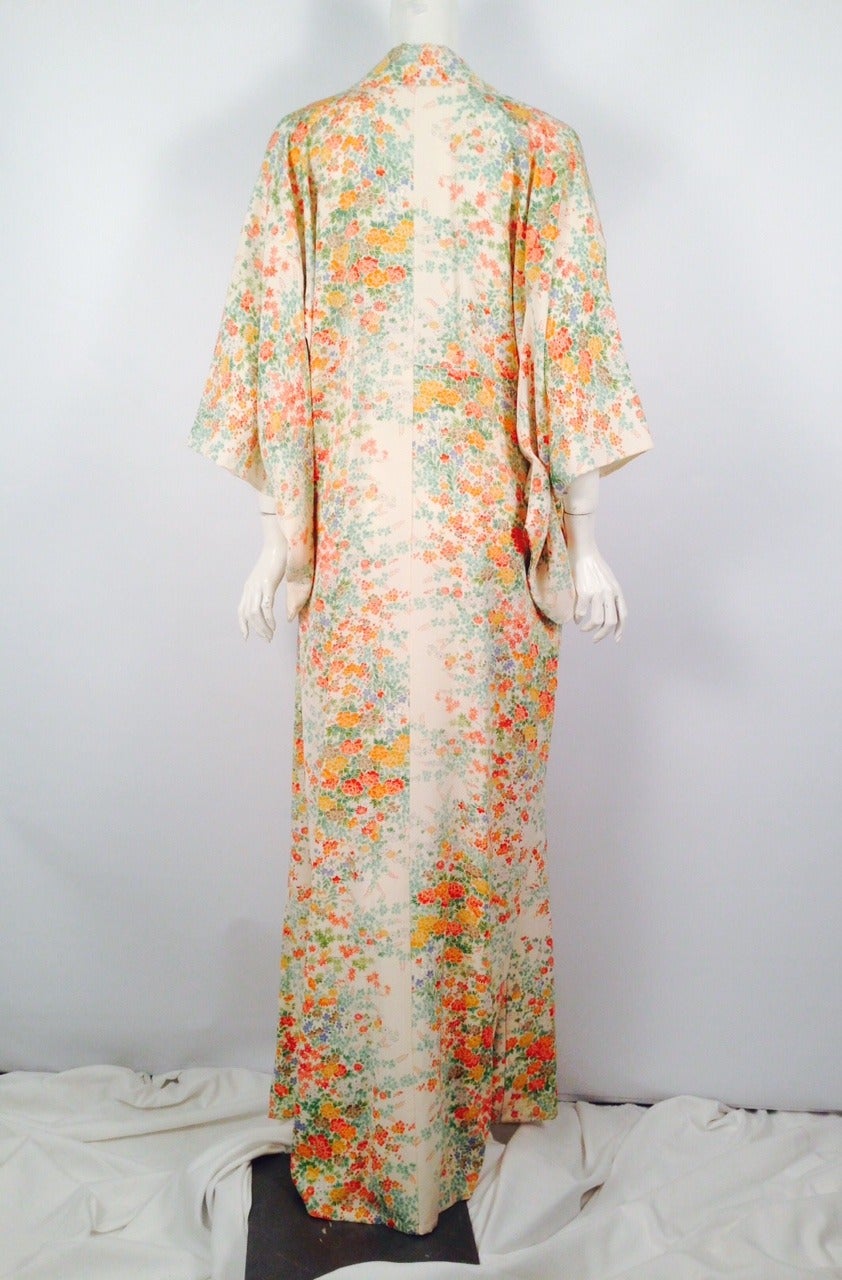 Vintage Silk Blend kimono is an ode to the tradition and time-honored design sensibility of the Far East.  A glorious floral print features natural tones including, orange, red, and green.  Periwinkle perfectly complements the warmer shades. Long on