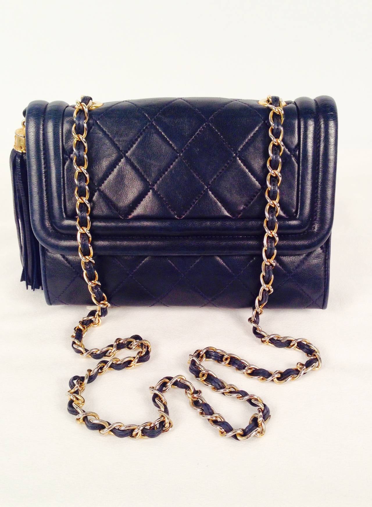 Vintage Chanel Navy Quilted Lambskin Single Flap Bag was crafted between 1989 and 1991.  Fit for a lady, bag features single flap, gilt woven leather shoulder strap, side tassel key charm and distinctive piping.  Interior is fully lined in luxurious