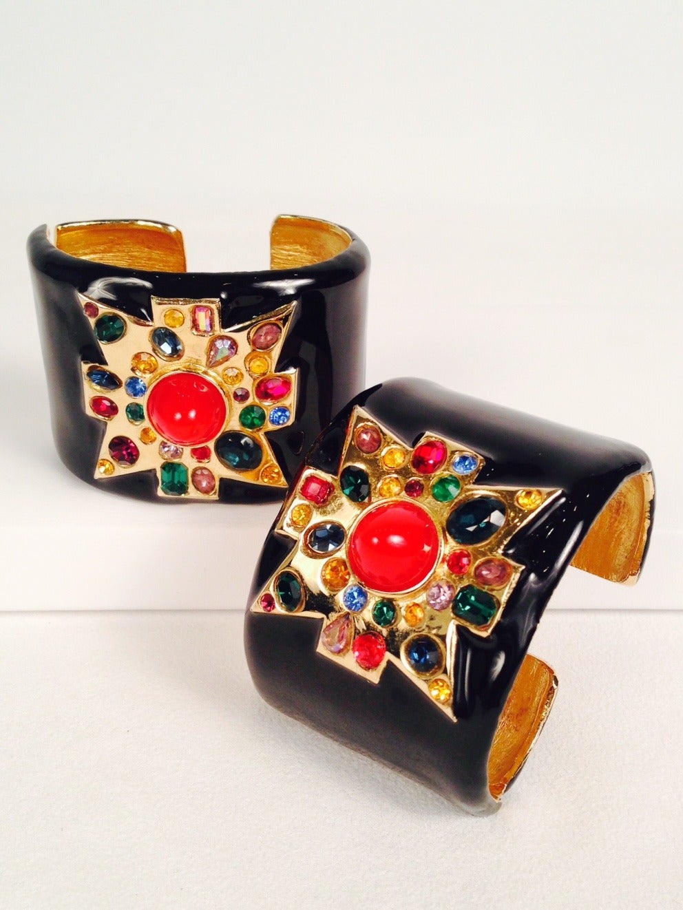 Kenneth Lane Black Enamel Cuff with Jeweled Maltese Cross pays homage to the Art Deco period and Jazz Age!  Features multi-colored faceted and cabochon stones and the most lustrous black enamel.  Side hinge allows for comfortable placement on wrist 