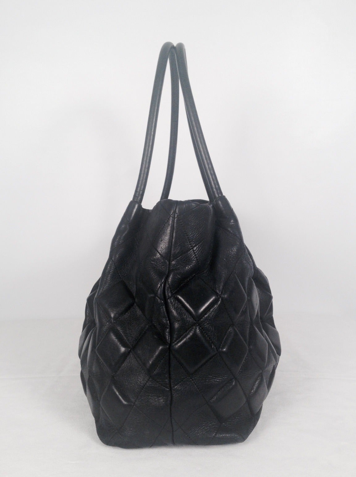 This exquisite Chanel deep navy tote was crafted between 2008 and 2009.  Hard to find?  Absolutely!  Highly collectible bag features signature diamond topstitch design with slightly gathered silhouette.  The piece de resistance? Alternating rows of