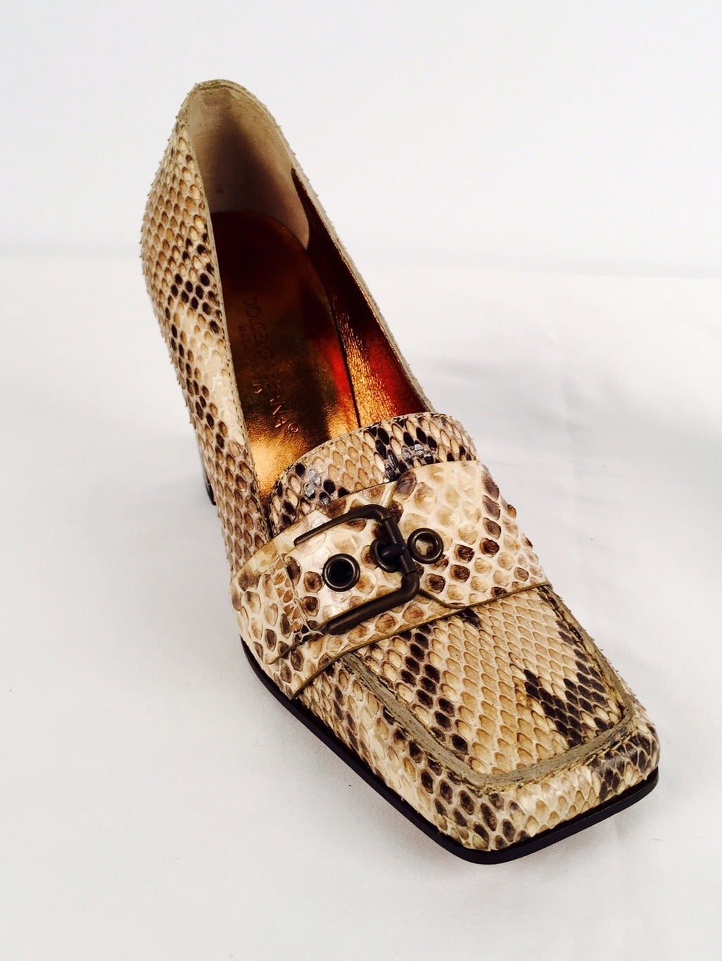 Dolce & Gabbana Snakeskin Square-Toe Pumps are sophisticated and timeless.  Features luxurious gold snakeskin and bronze metallic leather insole.  Leather soles.  Buckled strap across the vamp is the finishing touch!  3.5
