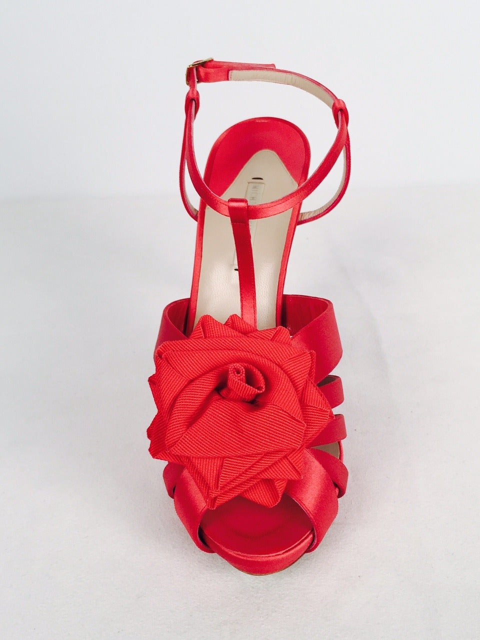 Scale new heights in these brand new Nicholas Kirkwood red satin high heel platform sandals.  Features include T-Strap construction and 5 strap vamp.  The piece de resistance?  A glorious rose in full bloom crafted from luxurious red grosgrain