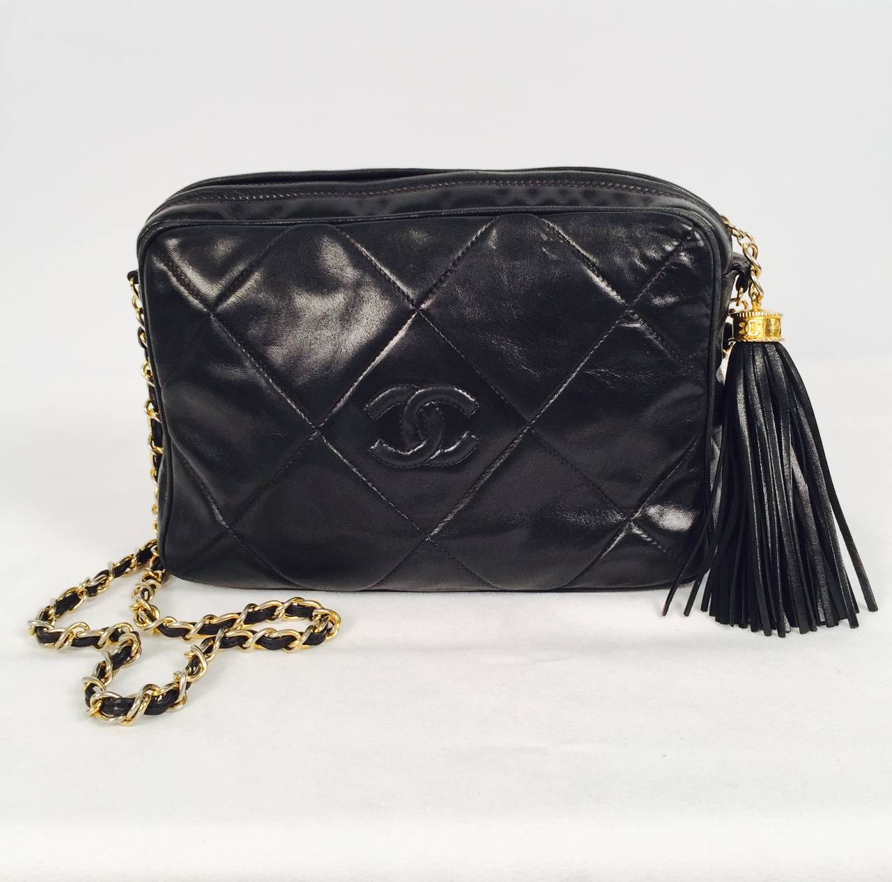 Vintage 1980s Chanel Camera Bag is a case study in why Chanel bags are so desired!  Features gold tone hardware, supple black lambskin, top zipper, single leather-woven chain, flirtatious tassel and expertly stitched double 