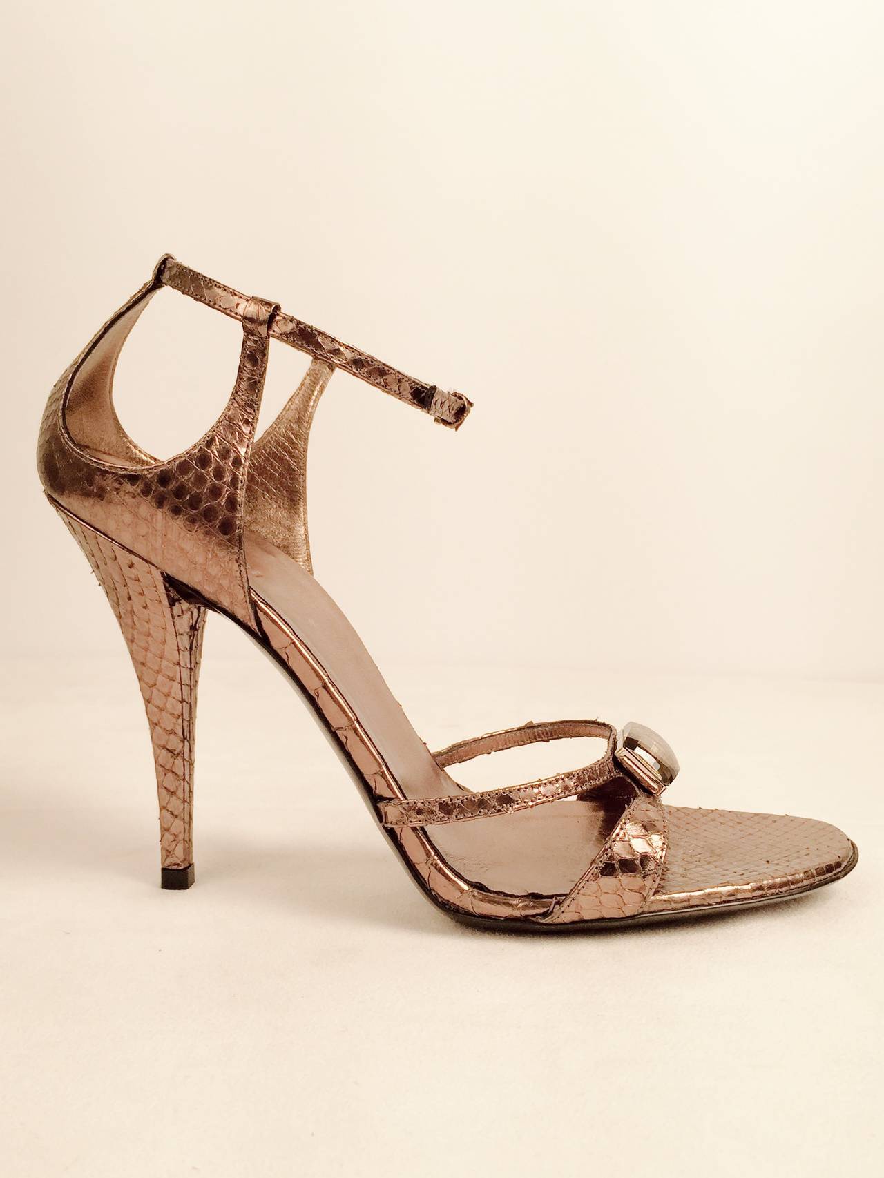 Gucci Mettalic Snakeskin High Heel Strappy Sandals embody the sensuous elegance that Tom Ford celebrated in the 1990s.  Ultra-luxurious snakeskin has been imbued with a slightly iridescent pewter finish.  Features adjustable ankle strap, double