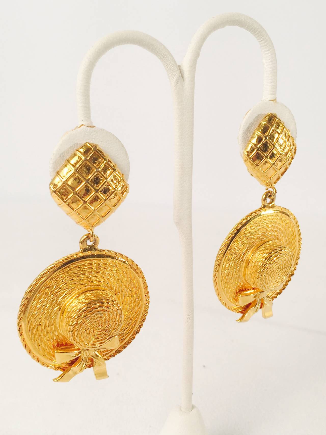 Vintage Chanel Straw Hat Earrings are worthy of Mademoiselle herself!  Clip on earrings feature gold plated straw hats with luxurious bows dangling from waffle weave diamond shapes.  Highly desired by collectors of all things Coco.    Properly