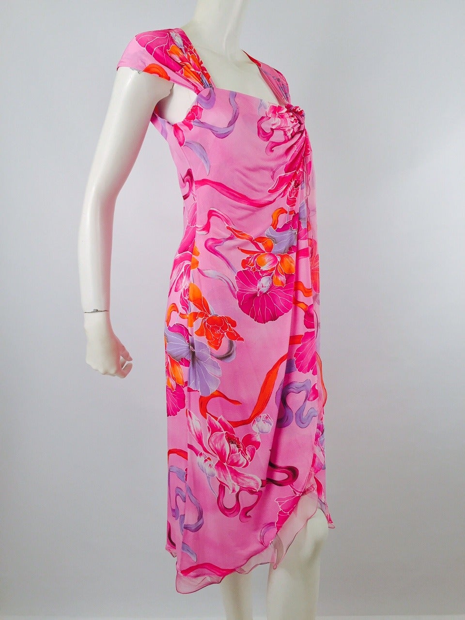 Pink Floral Bias Cut Wrap Dress is typical of Emanuel Ungaro designs...decidedly French...decidedly Flirty!  Features cap sleeves, asymmetric ruffled hem with lettuce edging, and exotic floral print.  Dress is gathered and knotted on top left.  Knot