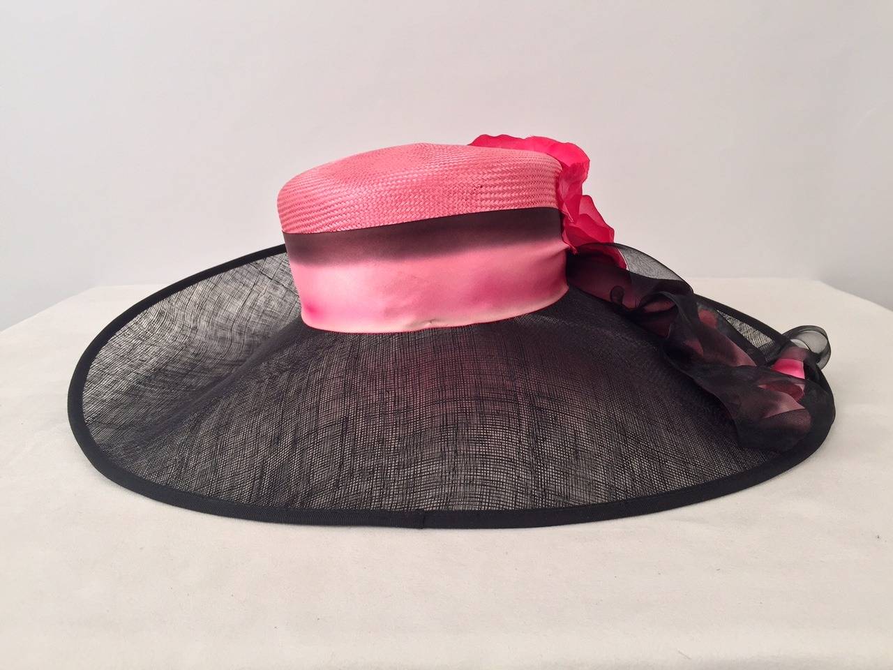 New Louis Green Wide Brimmed Black and Pink Hat is in full bloom!  Crafted from Sinamay and Raffia, hat features black brim, pink crown and elegant ombre ribbon.  Sophisticated crown is slightly off-center.  The piece de resistance?  A stunning