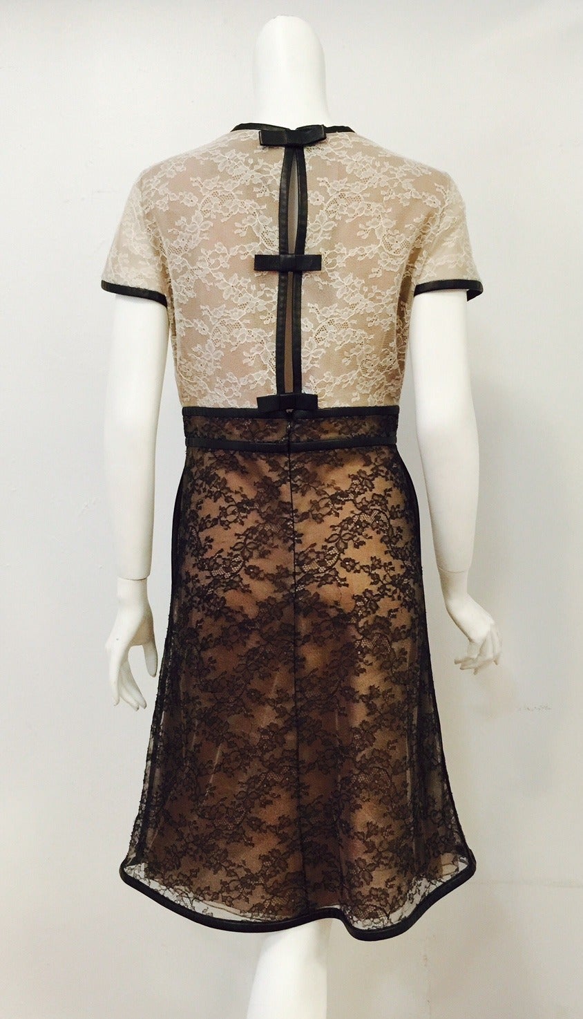 Valentino Runway Leather Trimmed Lace Cocktail Dress illustrates why Signore Garavani is considered one of the greatest couturiers ever!  Features round neckline, empire waistline and overall a-line silhouette.  Exquisite cream lace bodice and black