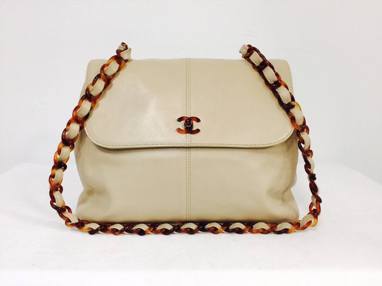 Tan Lambskin Shoulder Bag With Leather Woven Strap is quintessential Coco!   It's no secret that Chanel loved the color tan.  Why?  It goes with everything!  This larger soft lambskin bag features a half flap, luxurious fabric lining and two