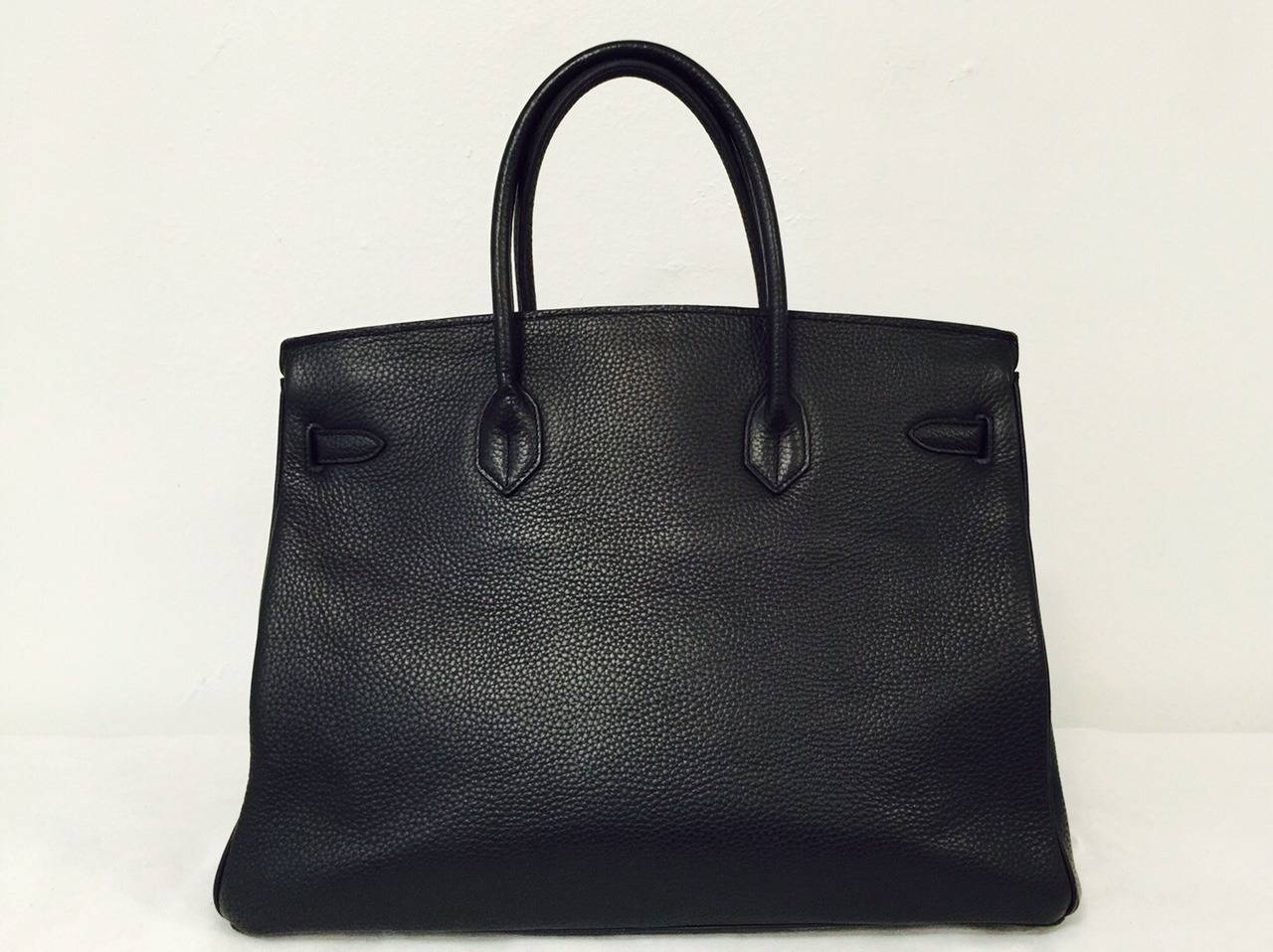 This classic, luxurious Black Hermès Birkin 40 cm handbag is finely crafted of Togo leather and has gold hardware.  Nearly indestructible, bag features the intricate Birkin Croix clasp, lock and key security and Hermès' signature cousu sellier