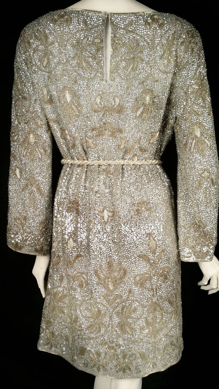 Make an unforgettable entrance in this extravagant Marchesa cocktail tunic dress encrusted in silver and gold-tone beads!  100% silk dress features boat neck, 3/4 bell sleeves, hook-fastening keyhole at the nape of the neck, and a fully adjustable,