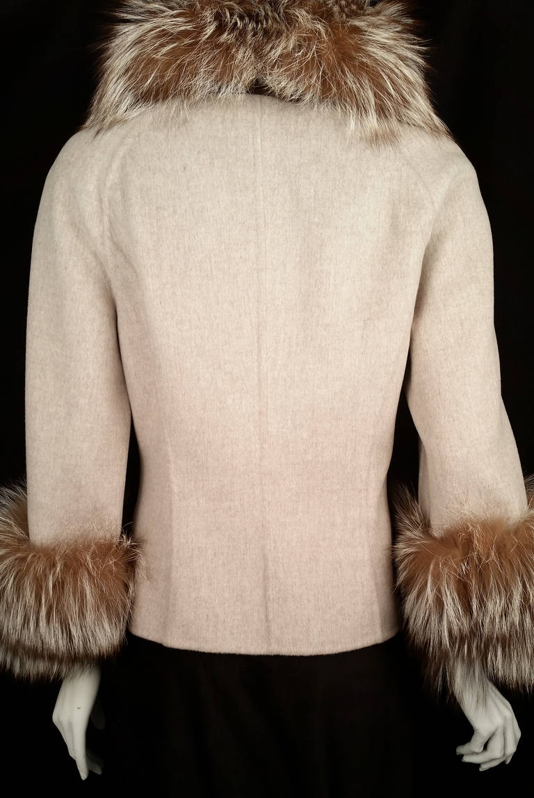 Sumptuous wool and cashmere short jacket is trimmed with removable silver fox collar and cuffs. Features raglan sleeves, feminine waist and front flap pockets with buttons. Jacket is finished with snap and button closures. Made in Italy.