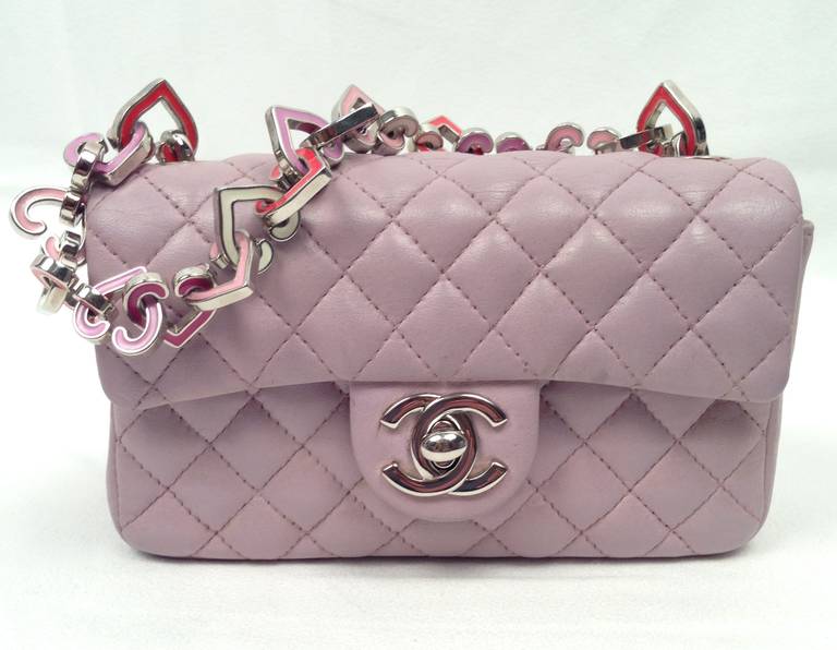 Unforgettable 2004 Limited Edition Valentine Heart Chain Bag is highly desired and collectible.  Crafted in signature pale lilac quilted lambskin, mini flap bag features multi-colored enamel heart chain and silver 