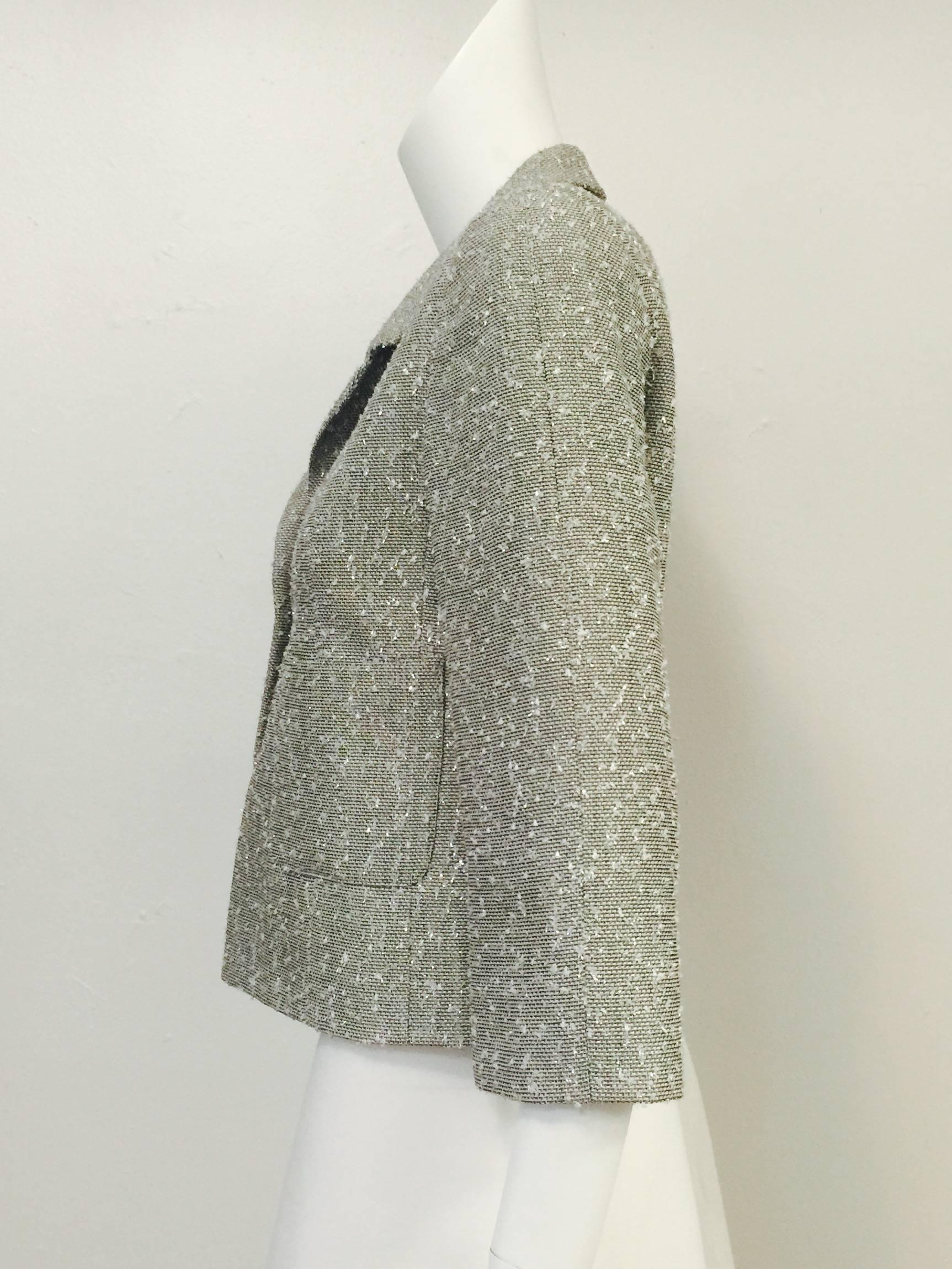 Chanel Spring 1999 Graphite and Silver Jacket is a must for all devotees of Coco.  Crafted from ultra luxurious wool blend fabric, weave is enhanced with  silver metal thread throughout!  Features cropped silhouette, bracelet sleeves, and two patch