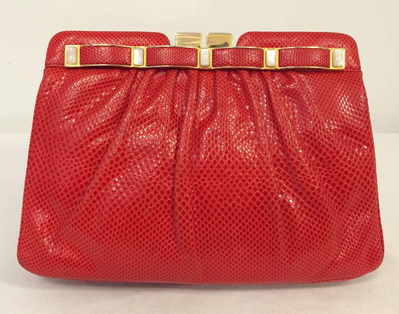 This stunning Judith Leiber lipstick red lizard evening clutch is in perfect condition!  With 10 pieces of mother of pearl decorating the top and the snap closure, this beauty can go from day to evening effortlessly.  Lined in luxurious red satin,