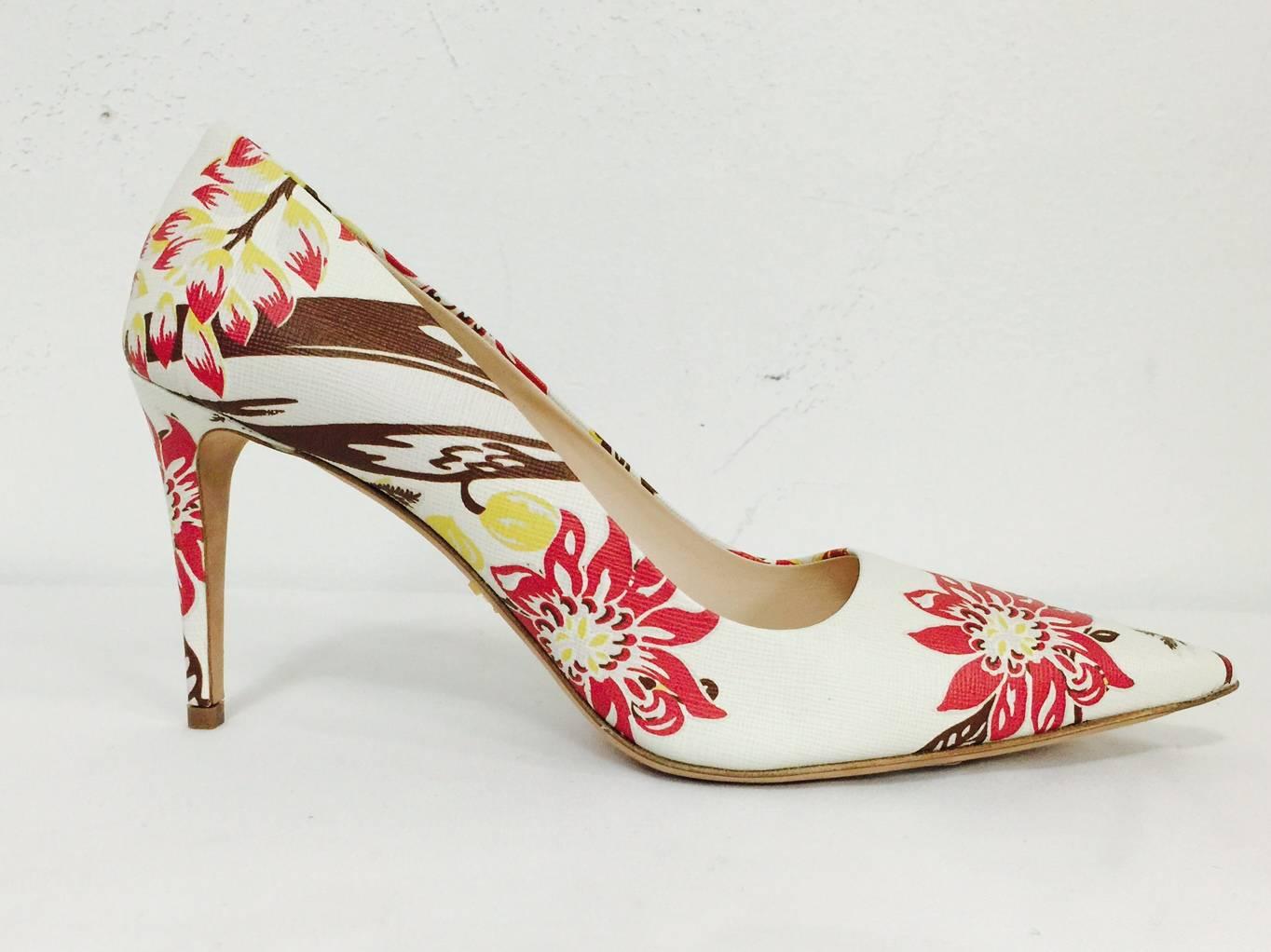Prada Pointed Toe Pumps take a classic shoe style and amplifies the feminine quotient!  Ivory shoes feature dramatic raspberry, brown, and yellow floral print in Saffiano leather!  Finished with leather soles and insoles.  Made in Italy.  Heel