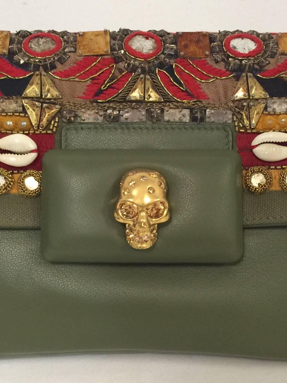 Embroidered Leather and Canvas Clutch With Gold Skull is a must for any connoisseur of all things Alexander McQueen.  Substantial clutch features supple olive green leather and flap front.  