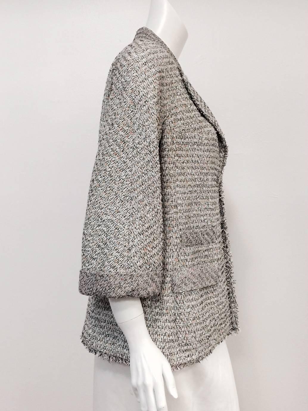 Chanel Spring Tweed Jacket With Rolled Cuffs and Frayed Hem is a wonderful addition to any collection celebrating all things Coco!  Features signature tweed in shades of pink, sky, sage, cream and black.  Raglan sleeves, notched lapel and single