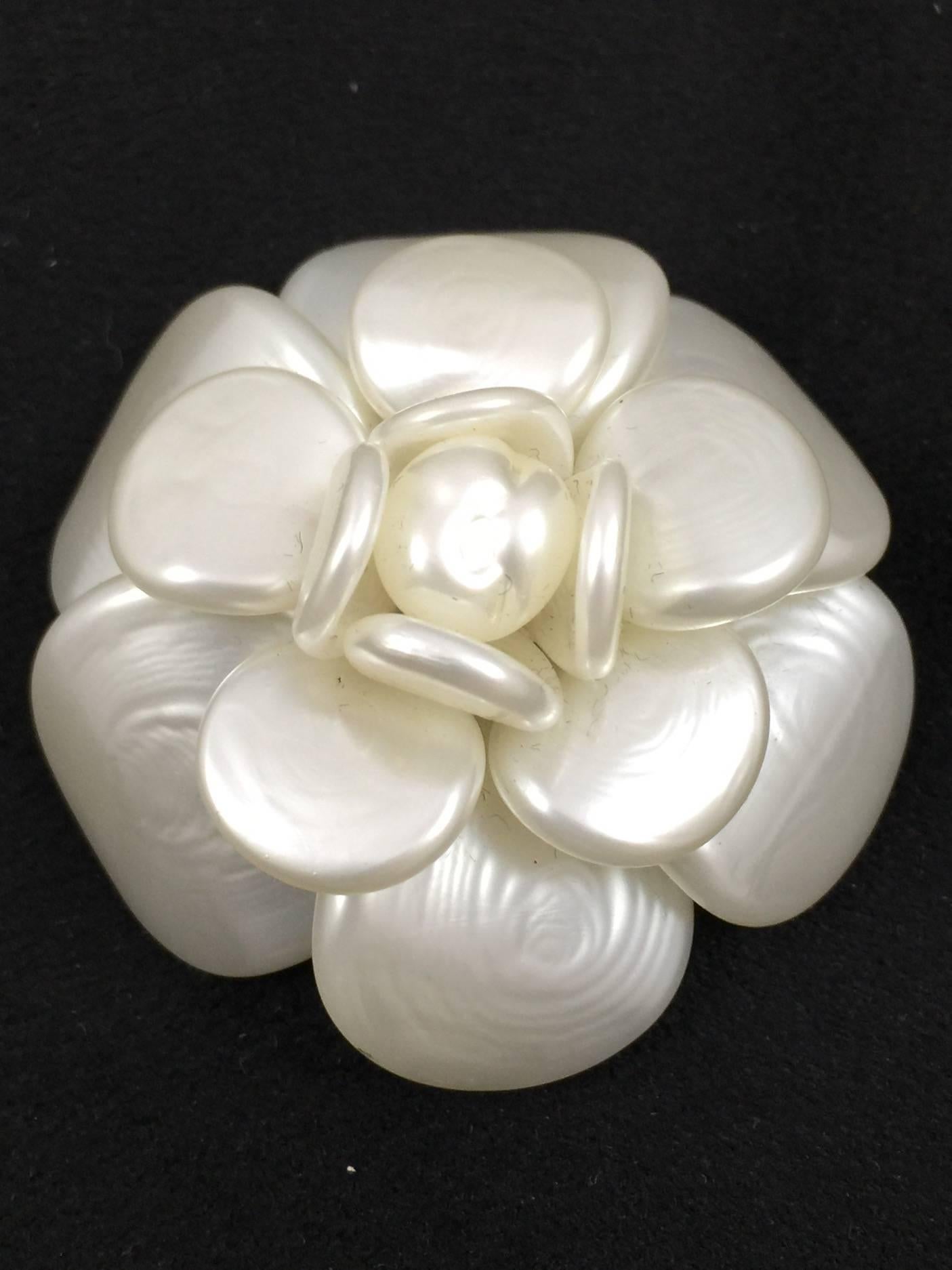 Mother of Pearl Camellia Pin is a signature Chanel accessory and a must for any connoisseur of all things Coco!  Instantly lends sophistication and timeless elegance to any jacket, sweater, or ensemble.  Properly hallmarked gold tone hardware.  Made