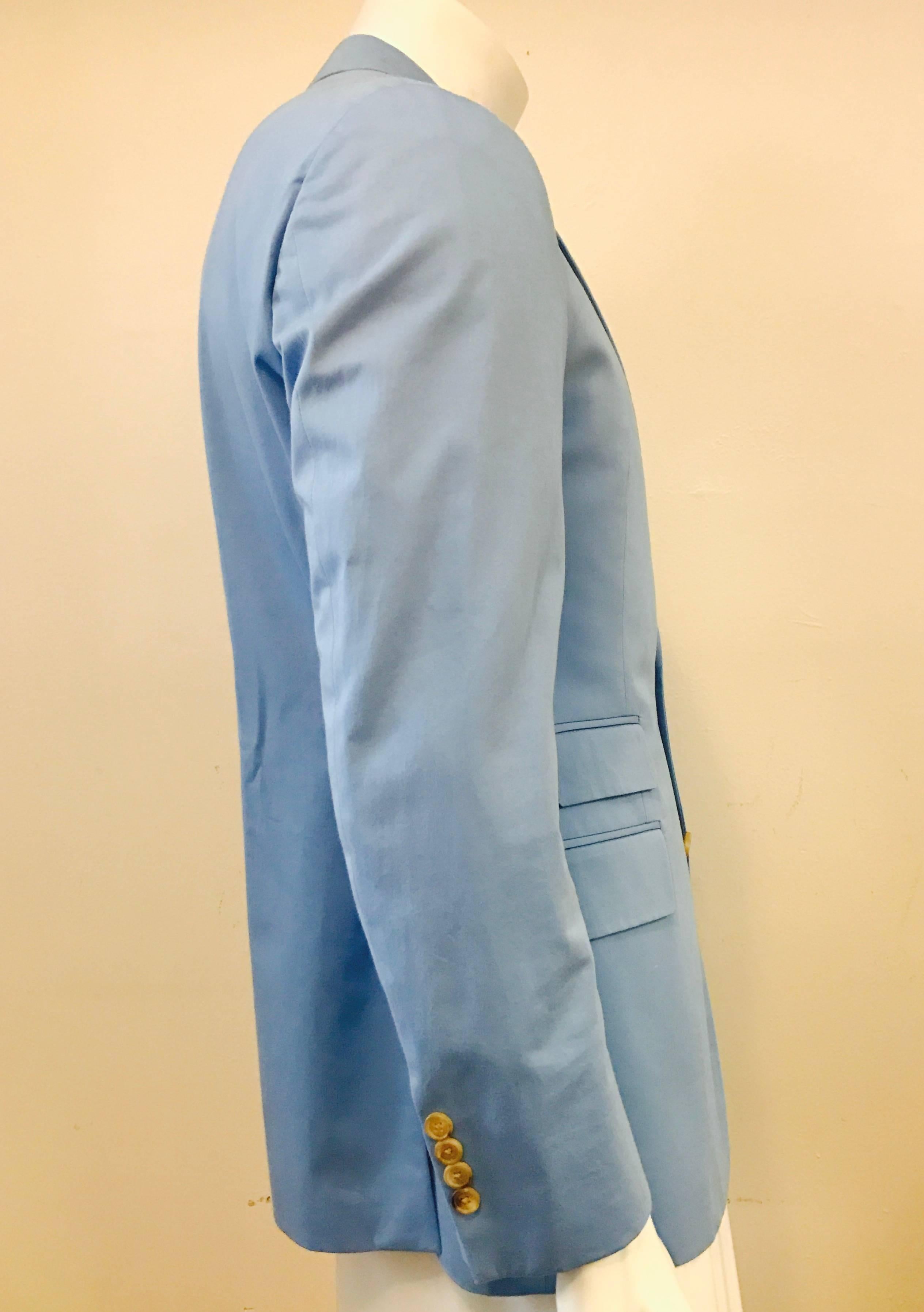 Lovely lightweight jacket in pale blue cotton, fully lined, with three interior slit pockets.  There are three flap pockets that have never been un-stitched, and one slit pocket on the front, as well as a boutonniere on the notch collar.The back