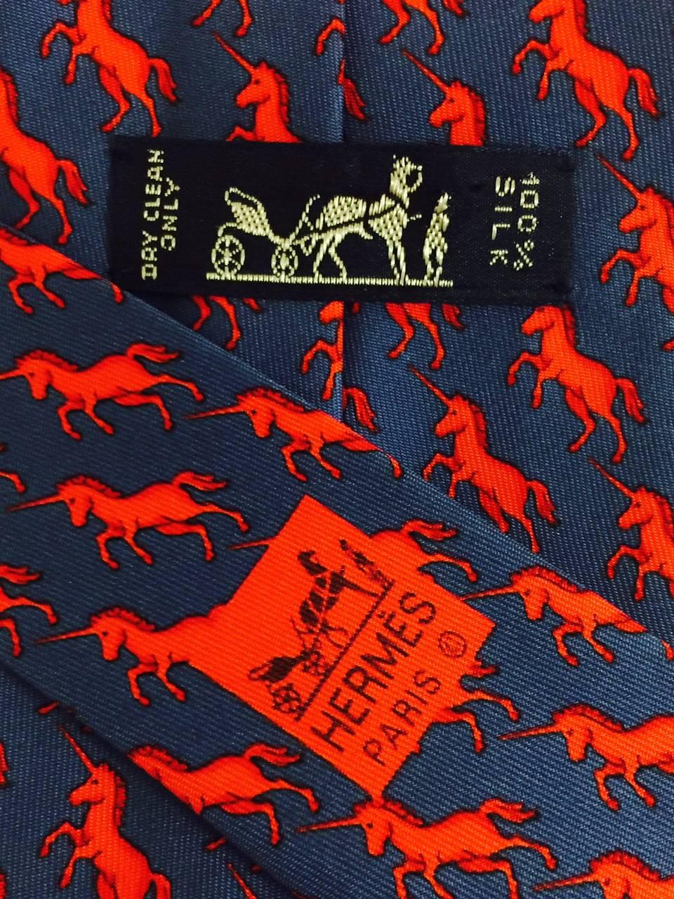 Fun Hermes neck tie in indigo blue with shaded red unicorns prancing along.  Lovingly made in the 1980's, a collectible item.