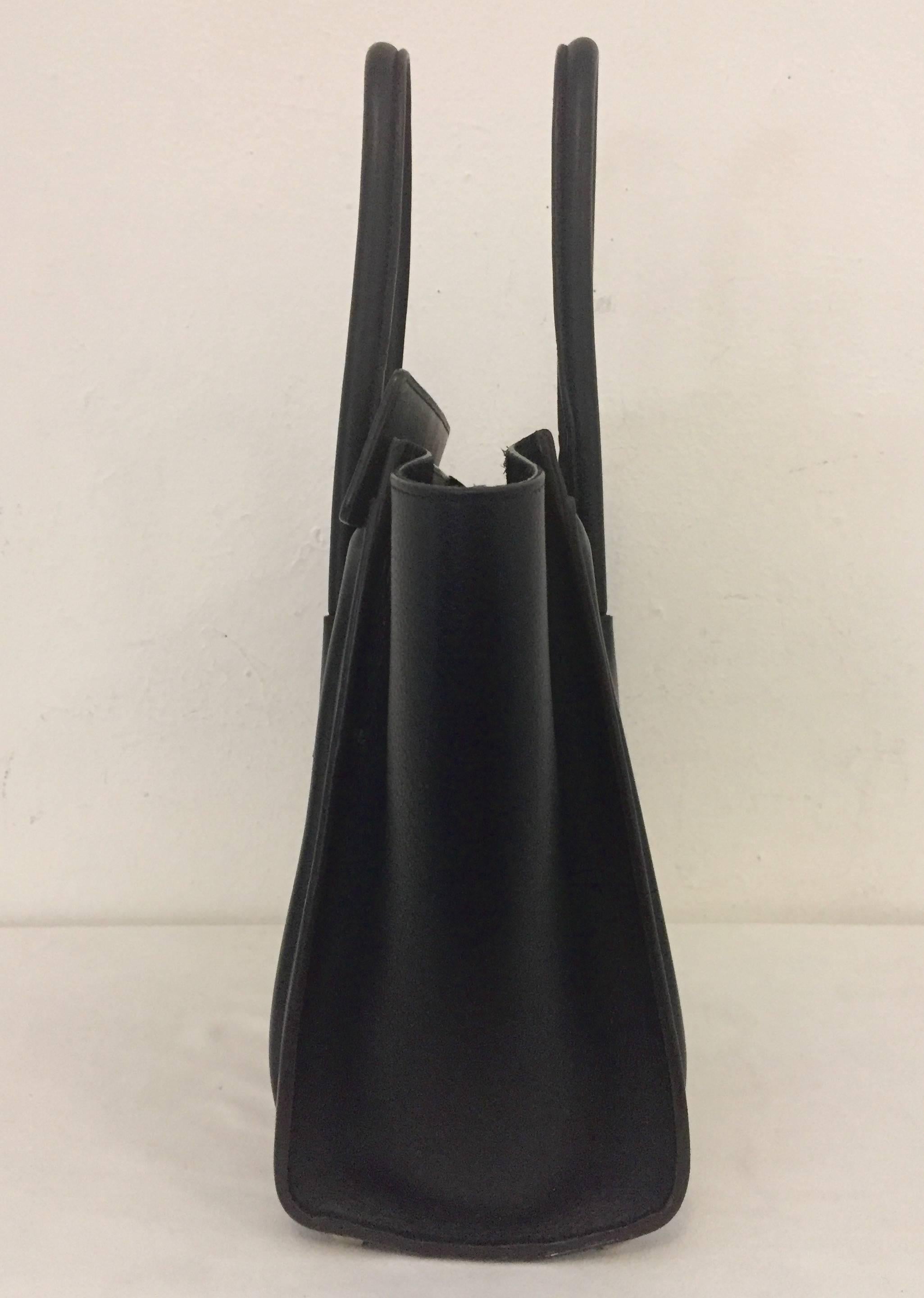 Celine Chic and minimalistic Black handbag with top zipper closing and 2 handles with Drop of 5.5 inches.  Black inside with side zippered slot for additional security of your essentials and on the front of the bag there is also another small