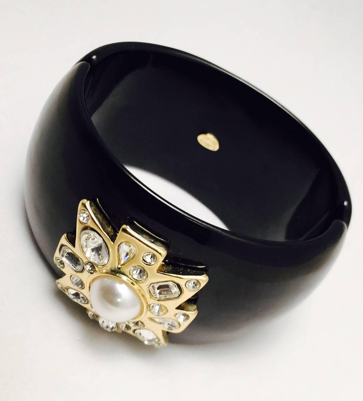 Kenneth Lane pieces are becoming highly collectible!  This fabulous black resin cuff, with magnetic closure, features a stylized Maltese cross embellished with Swarovski crystals in round, oval, pearl and emerald cut shapes, centered with a faux