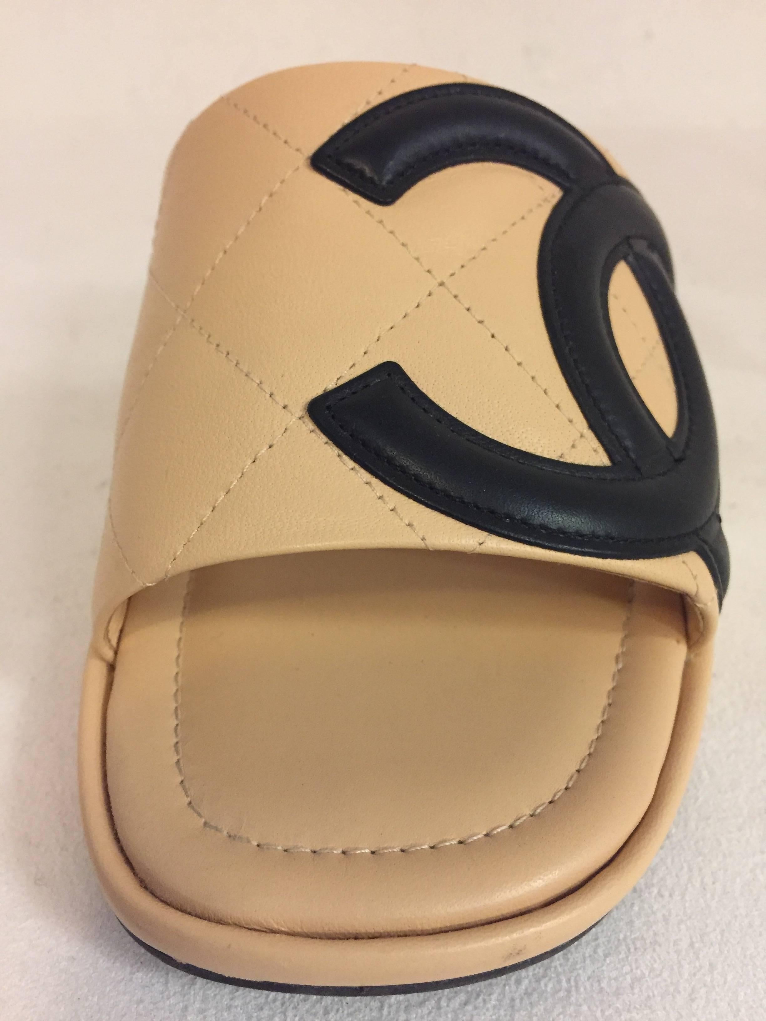Chanel Cambon casual quilted slides in beige with black interlocking CC embroided on outer side of strap.  These slides can be paired perfectly with jeans or any daytime attire.  These slides are in excellent condition in size 6.50 and Made in