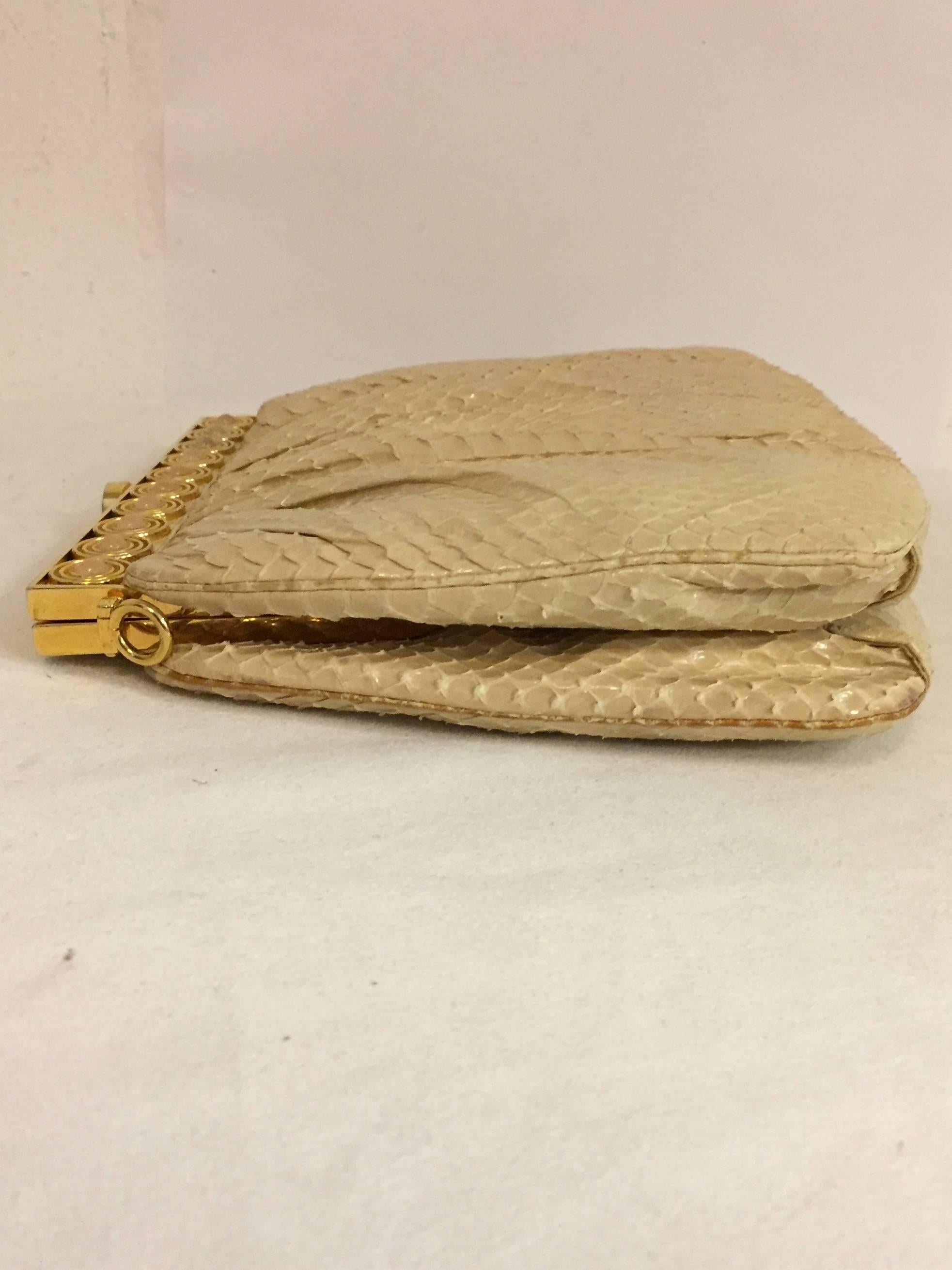 Stylish pleated cream colored skin, tonal stitching with gold tone hardware at closure.   The snakeskin strap is also cream color and can be removed.  Beautifully constructed in 1986 in the authentic Judith Leiber fashion.  The inside has one