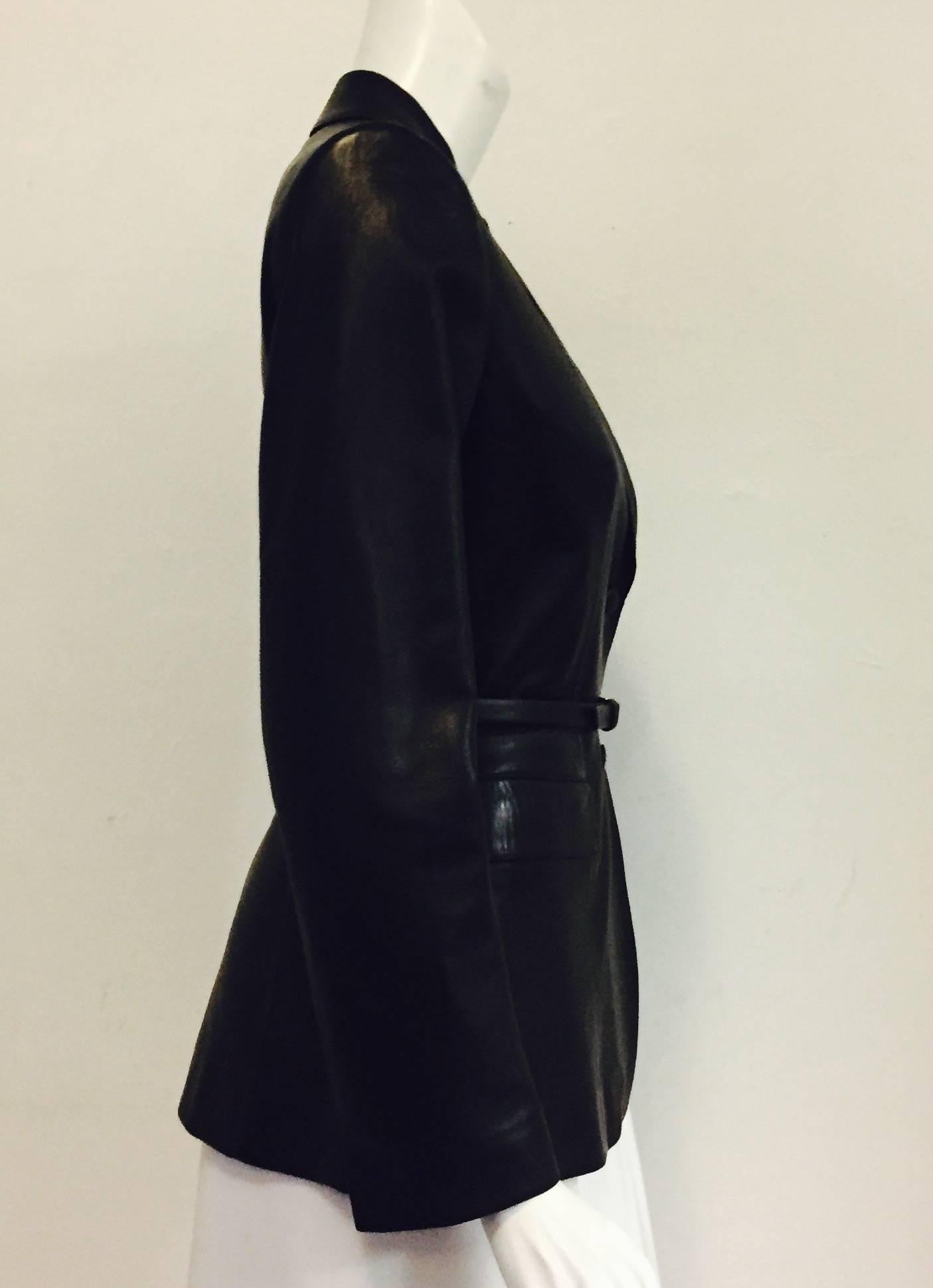 Prada black leather jacket is a statement unto itself!  Features undeniably supple Italian lambskin, notched collar, two covered buttons for closure and two flap pockets.  Accentuated waistline perfects the Prada appearance.   The back has a slit at